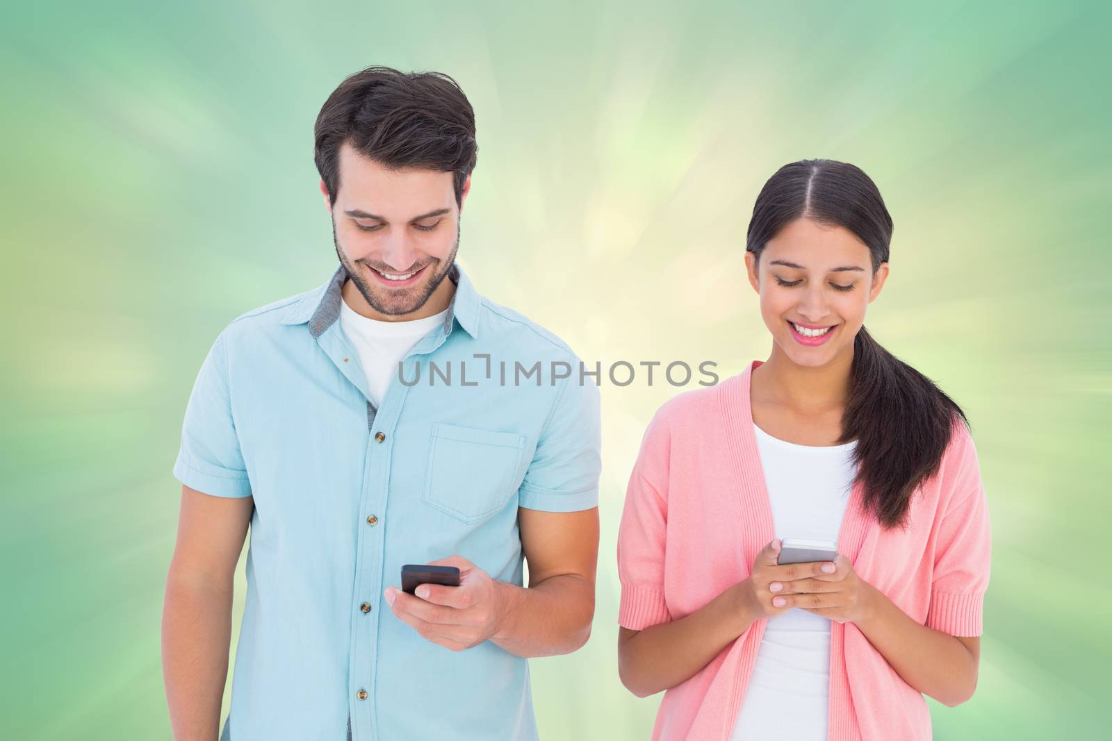 Happy couple sending text messages against green abstract light spot design
