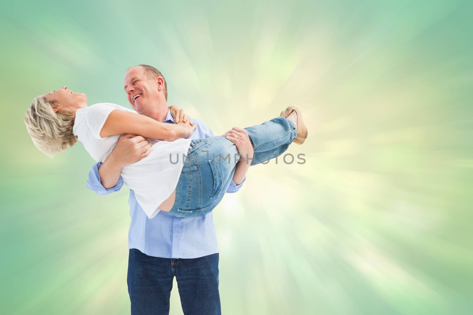 Mature man carrying his laughing partner against green abstract light spot design