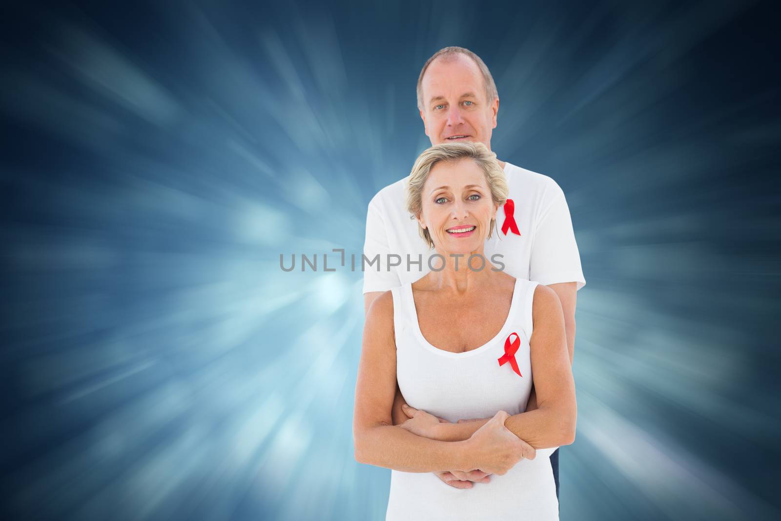 Mature couple supporting aids awareness together against blue abstract light spot design
