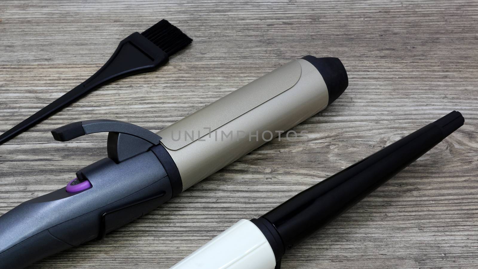 Hair style, ceramic Curling iron and hair brush on wooden table