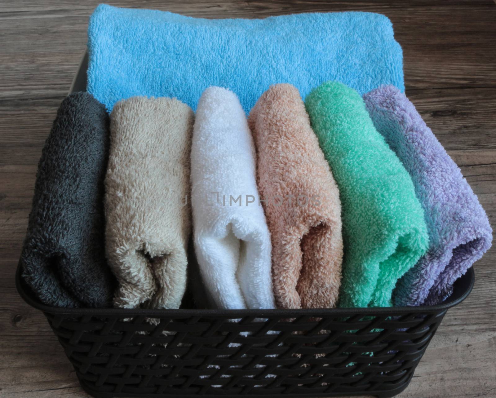 colorful towels in a basket on a wooden table