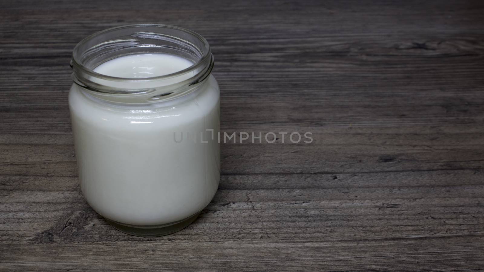 Greek yogurt, milk in a glass jar on a wooden table, detox, diet