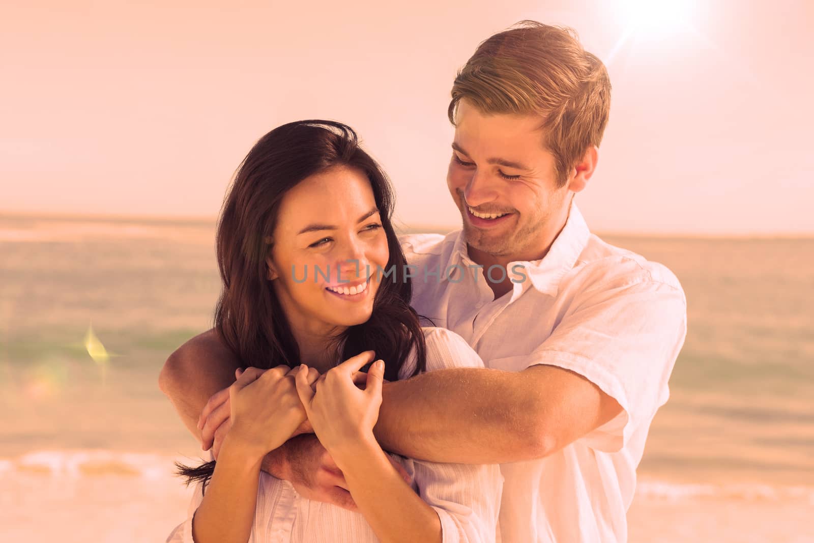 Cheerful couple relaxing and embracing on the beach during summer