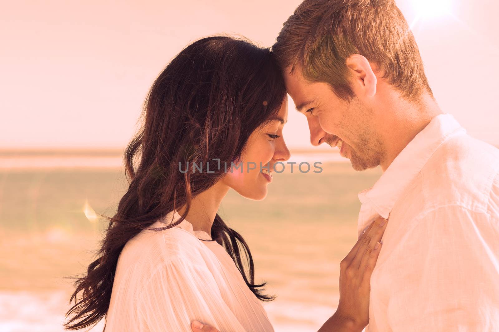 Romantic couple relaxing and embracing on the beach  by Wavebreakmedia