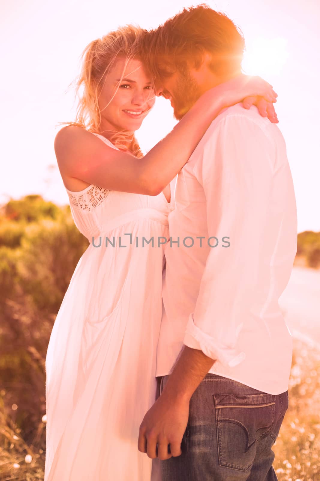 Attractive couple embracing by the road on a sunny day