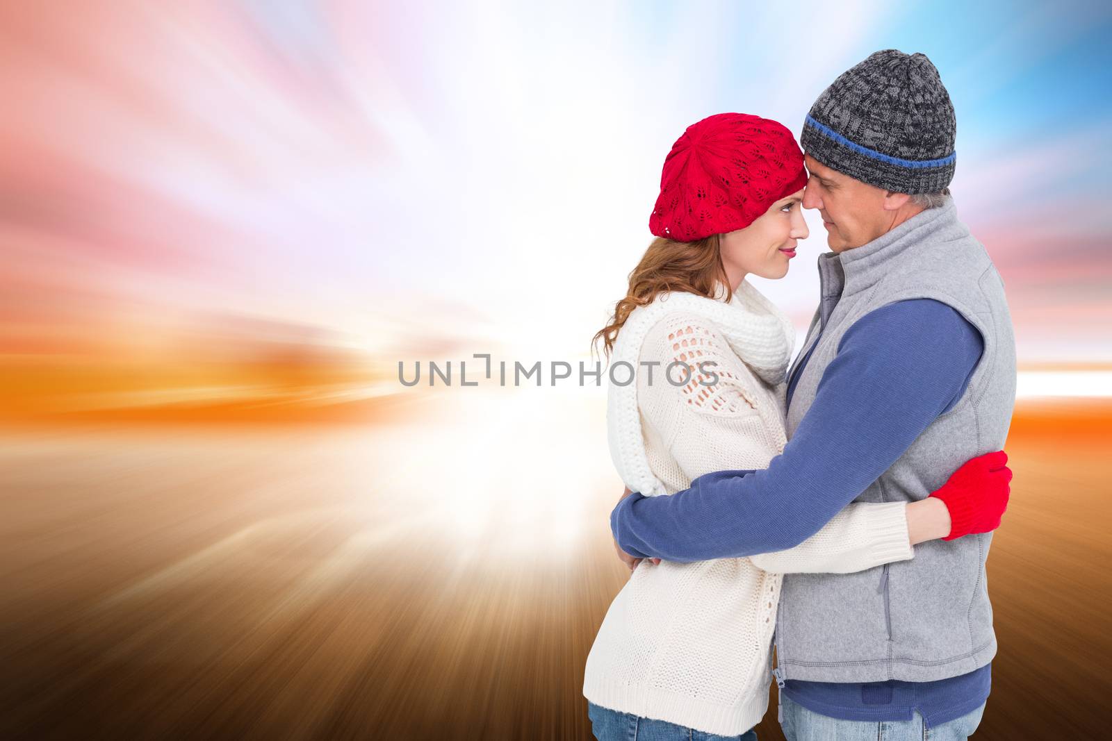 Composite image of happy couple in warm clothing hugging by Wavebreakmedia