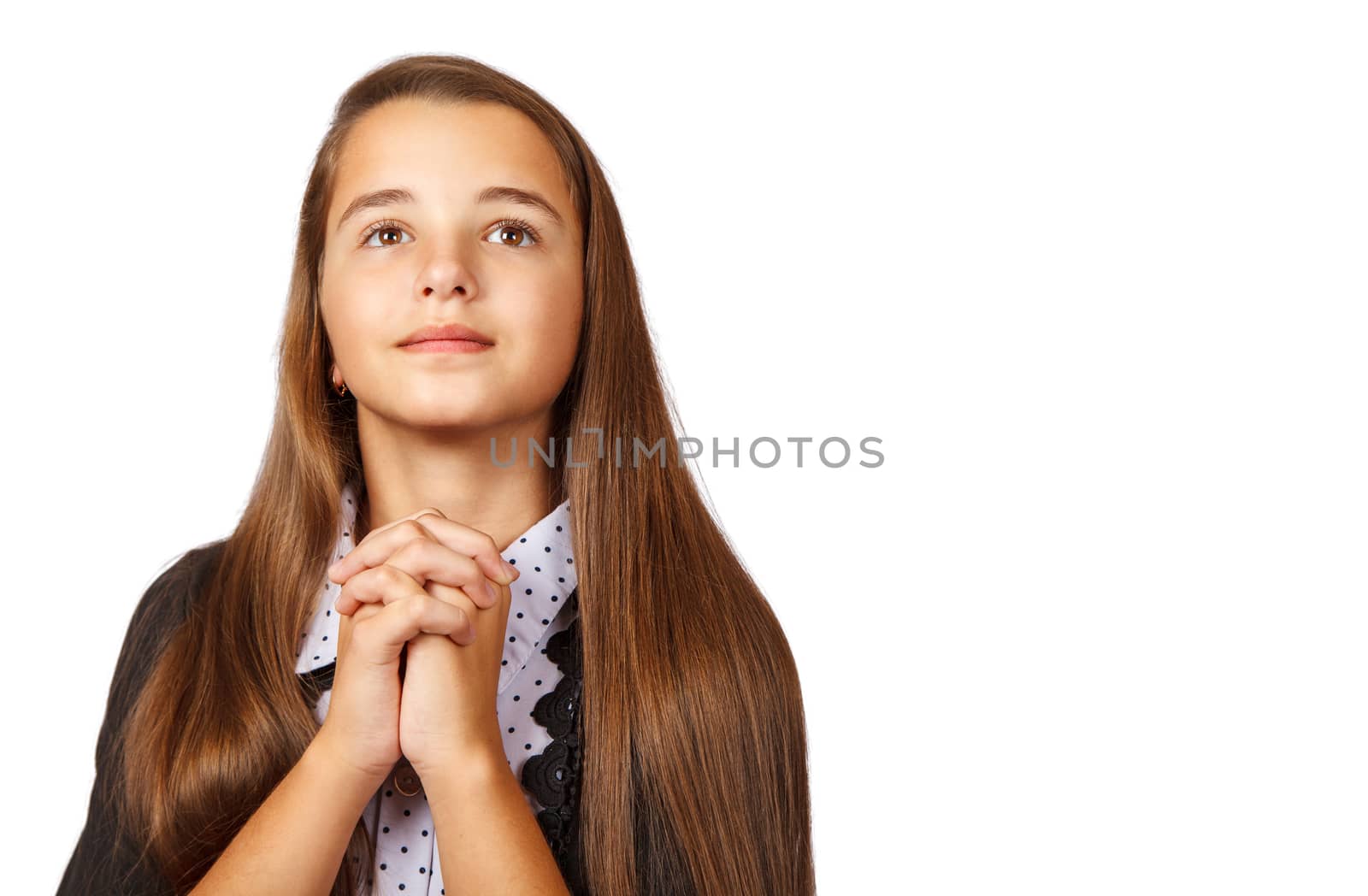 portrait of teen brunette girl looking up with clasped hands on white