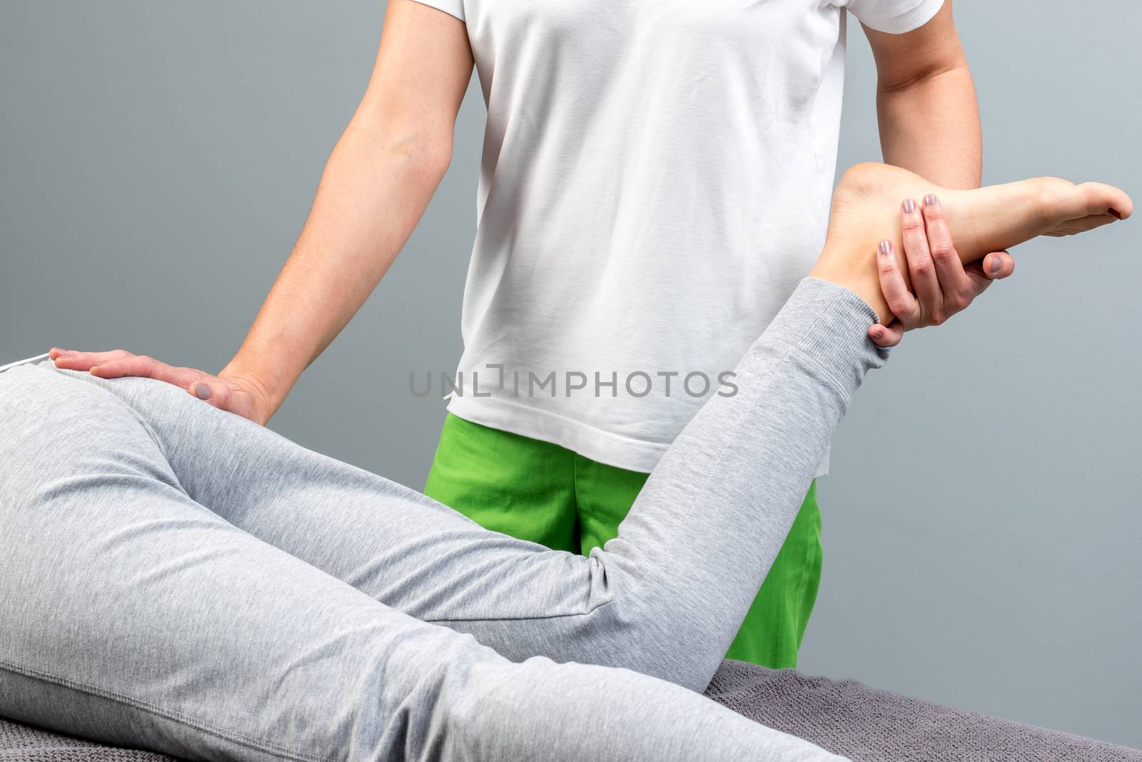 Close up detail of physiotherapist manipulating female leg and knee.