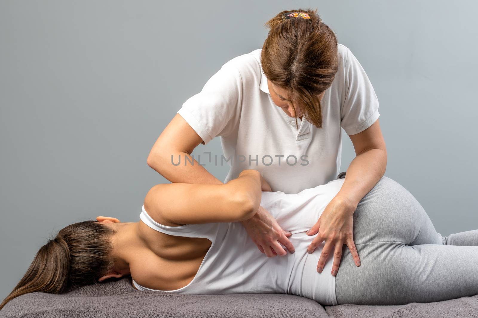 Female therapist doing osteopathic spine treatment on patient. by karelnoppe