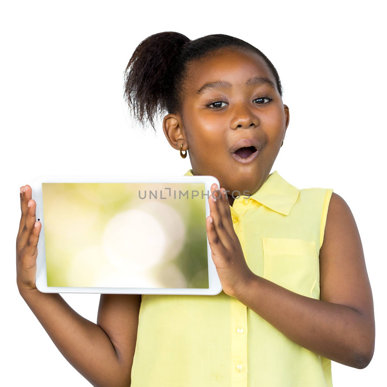 Close up fun portrait of cute little african girl with ponytail holding blank digital tablet. Kid with surprised facial expression isolated on white background.