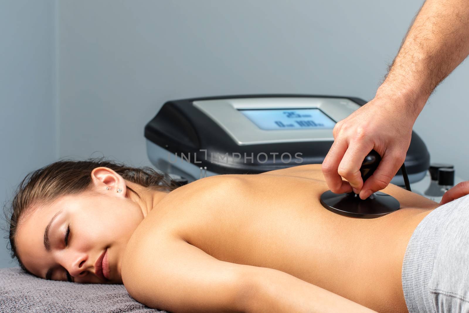 Young woman having electrotherapy session. by karelnoppe