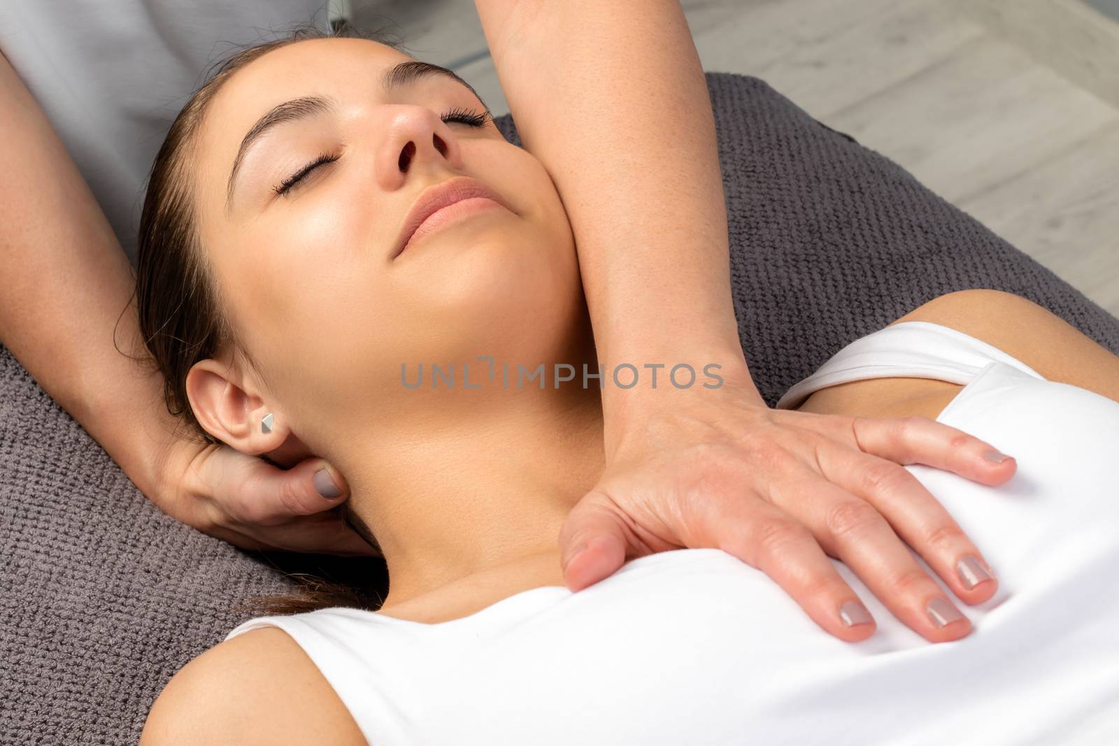 Close up top view of young woman receiving physical neck and chest treatment.