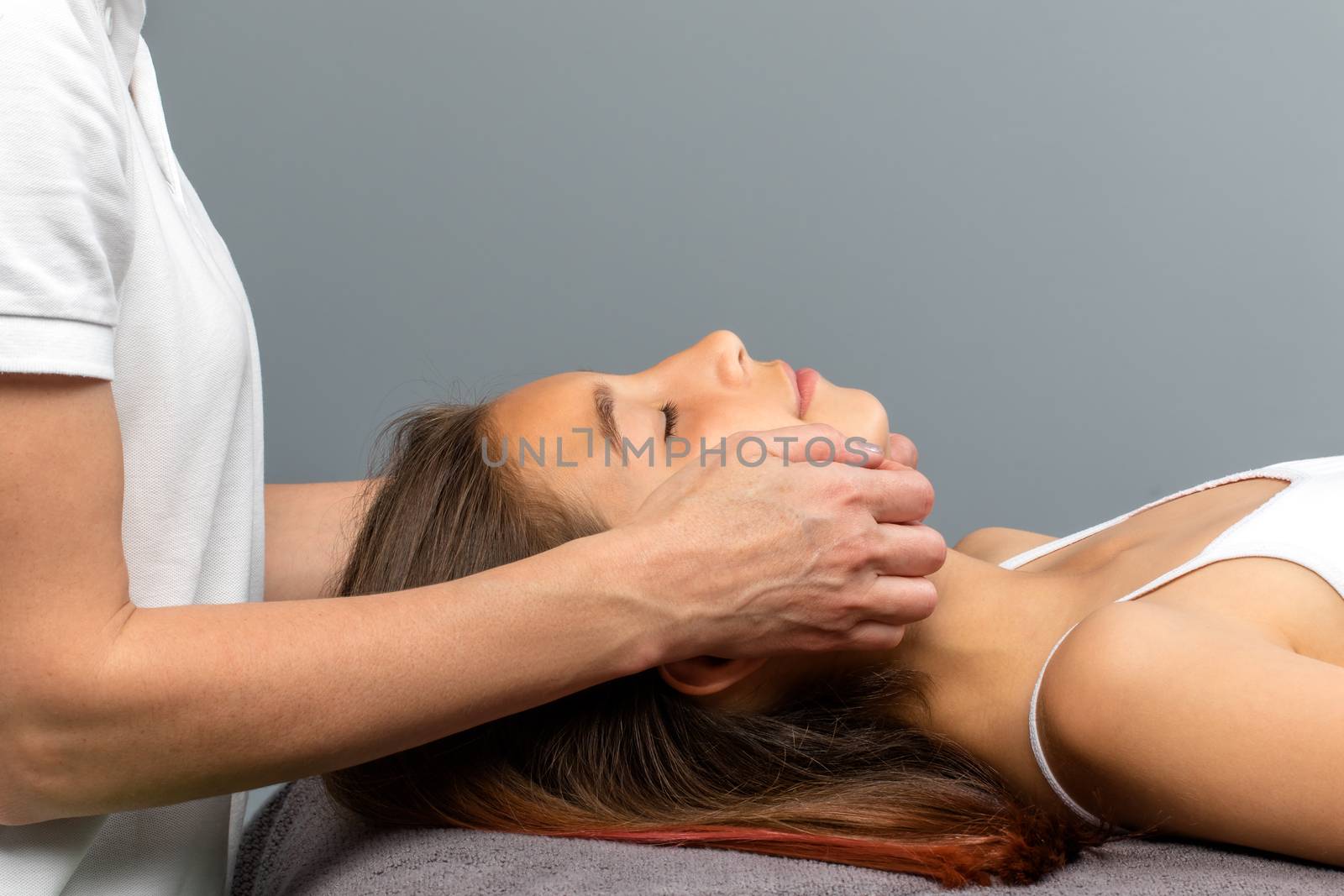 Close up of therapist doing osteopathic treatment on little girls chin.