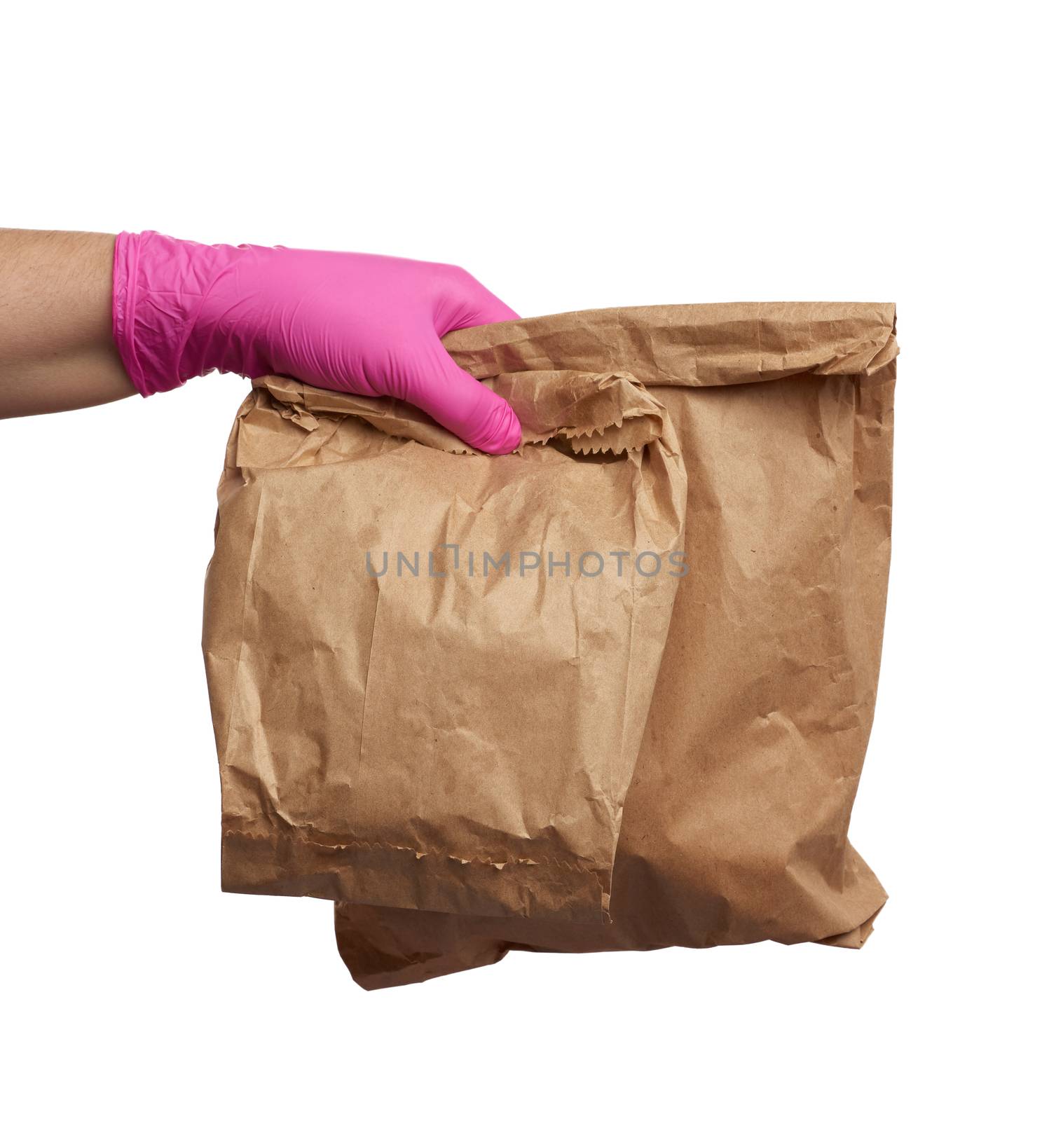 hand in a pink latex glove holds a full paper bag of brown craft paper, concept of remote and contactless food delivery, safe receipt of orders, white background