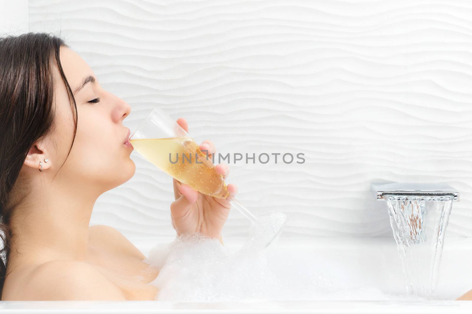 Young woman relaxing with champagne in foam bath. by karelnoppe