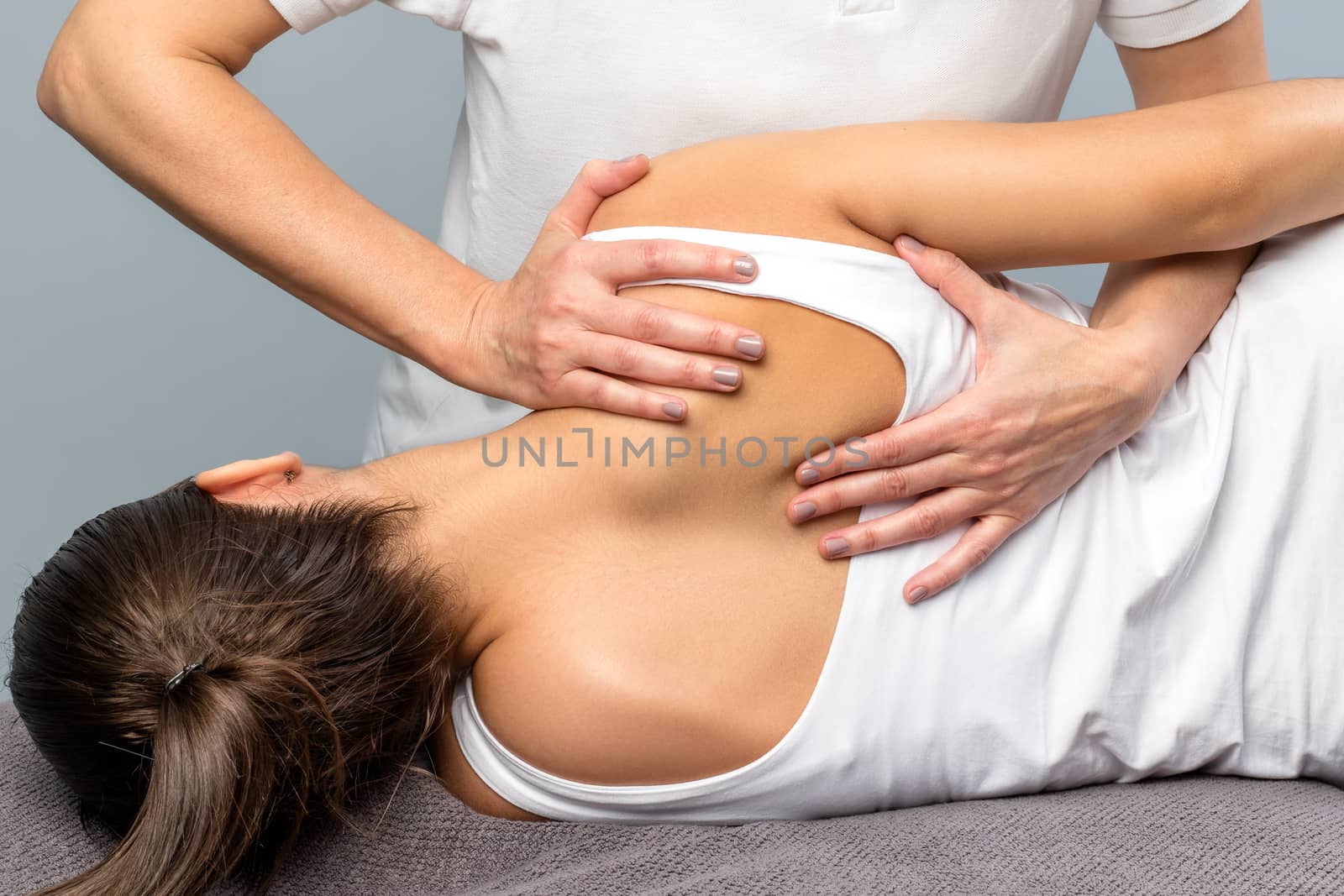 Close up of detail of female physiotherapist doing shoulder blade treatment on patient.