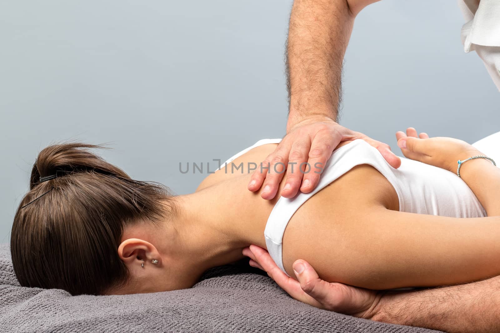 Girl receiving curative osteopathic treatment on shoulder. by karelnoppe