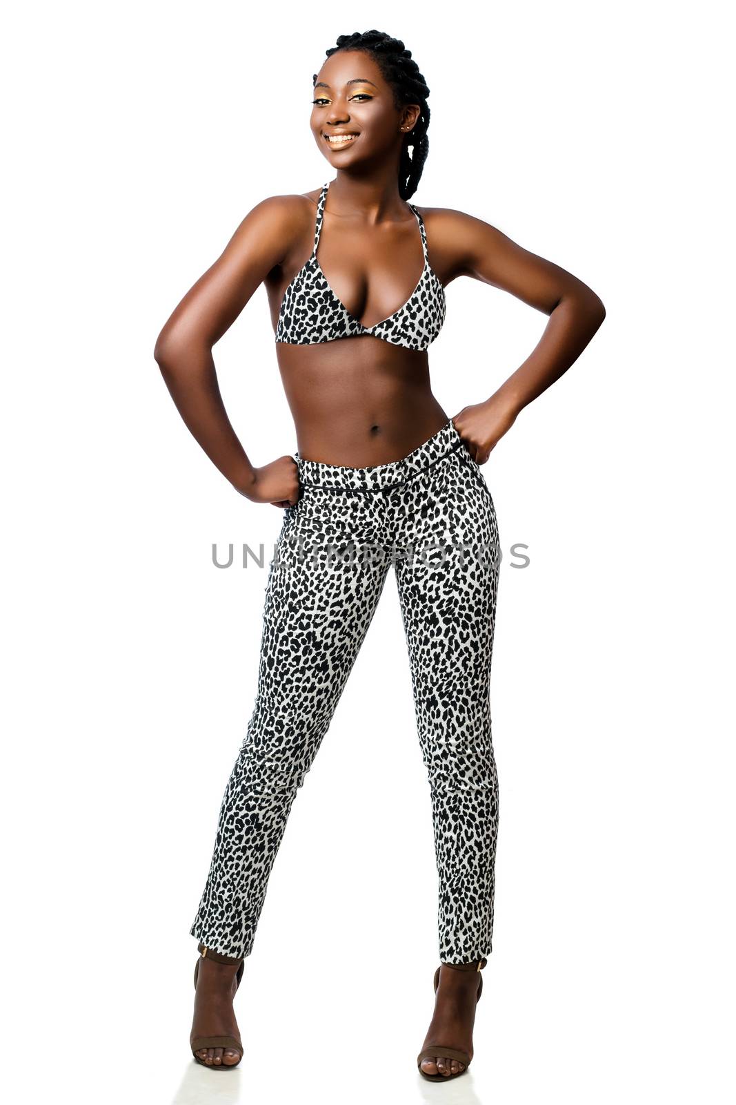 Attractive african woman in leopard pants standing with hand on  by karelnoppe