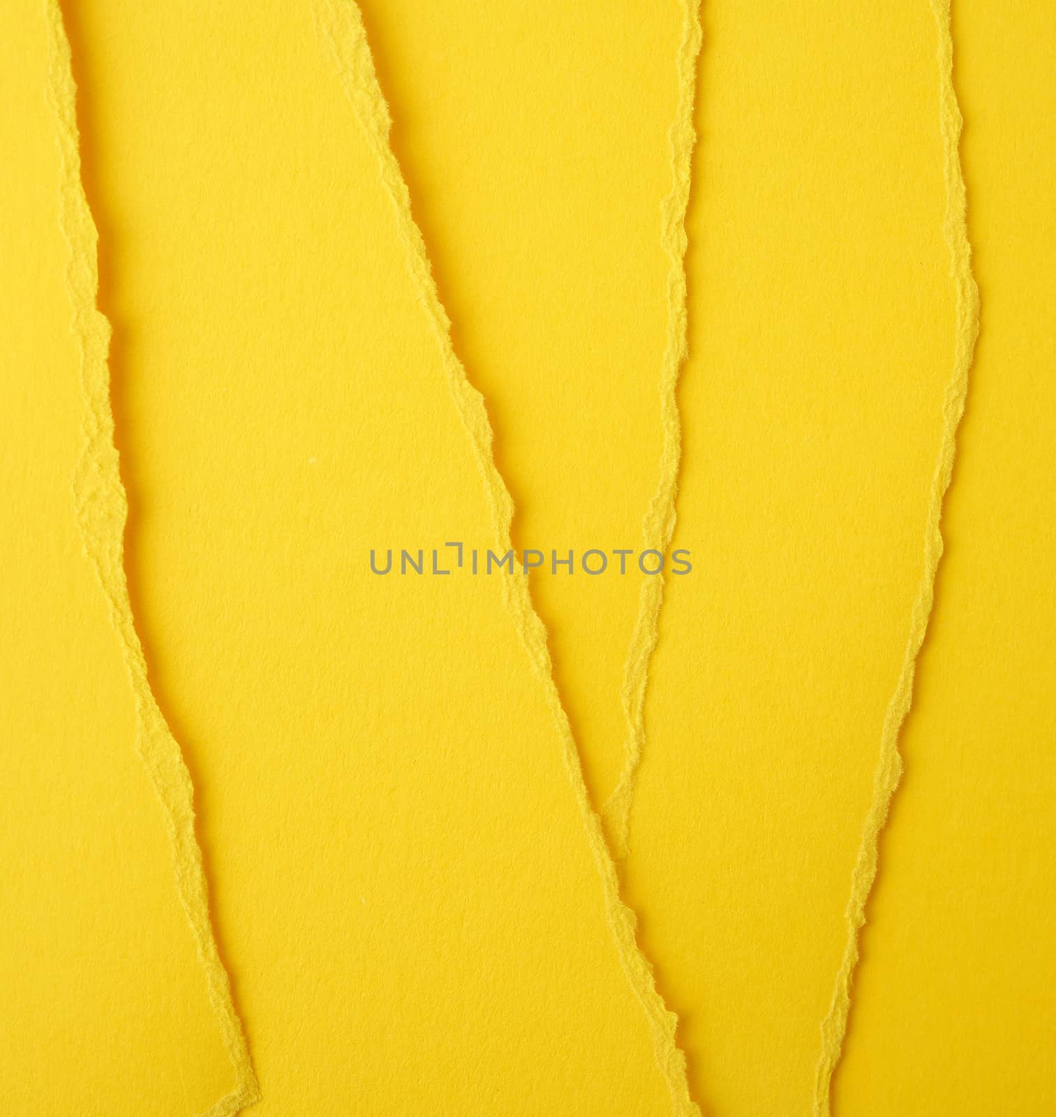 background of layered yellow torn paper with a shadow, backdrop and template for designer, close up