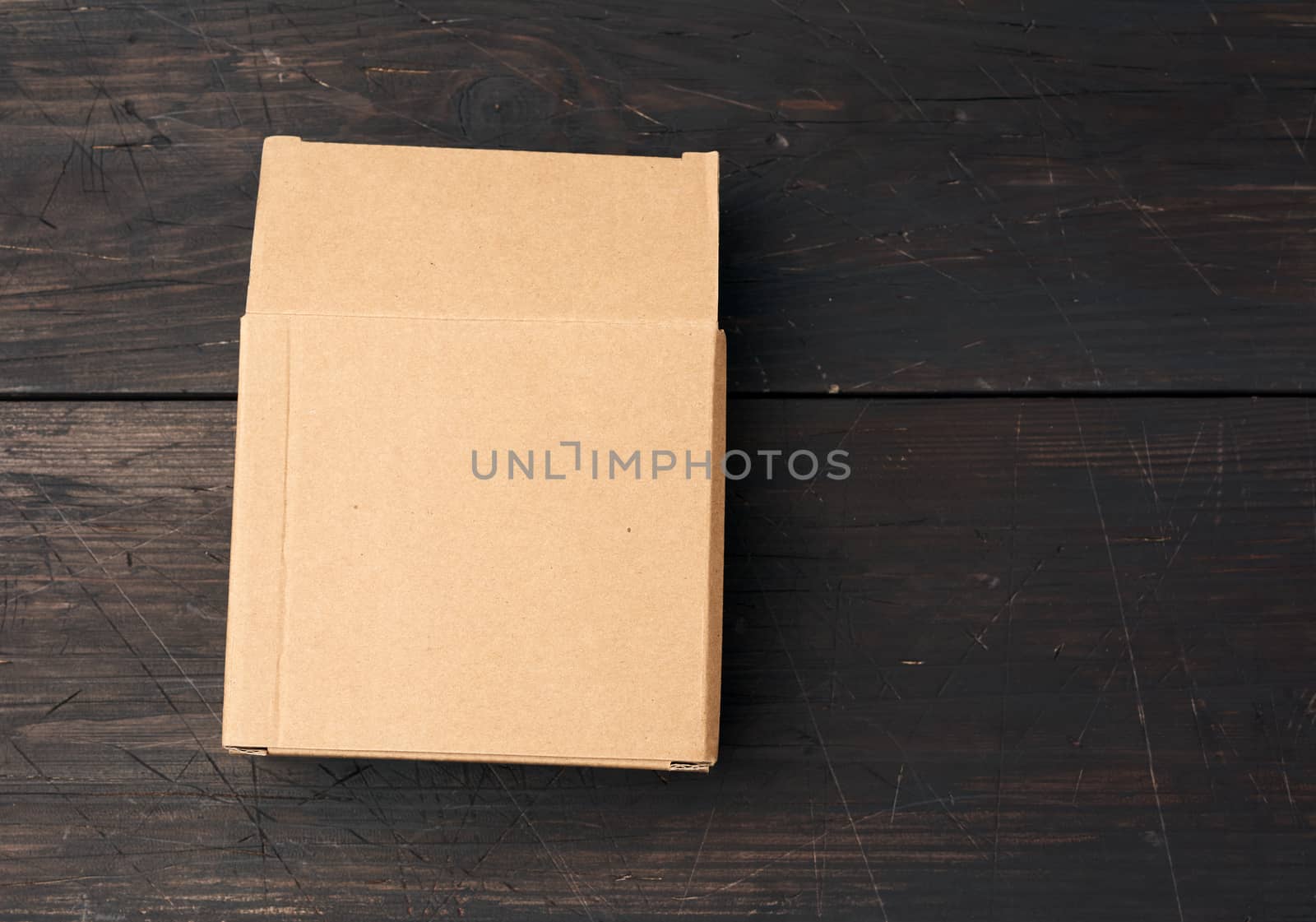 brown square cardboard box for transporting goods on brown woode by ndanko