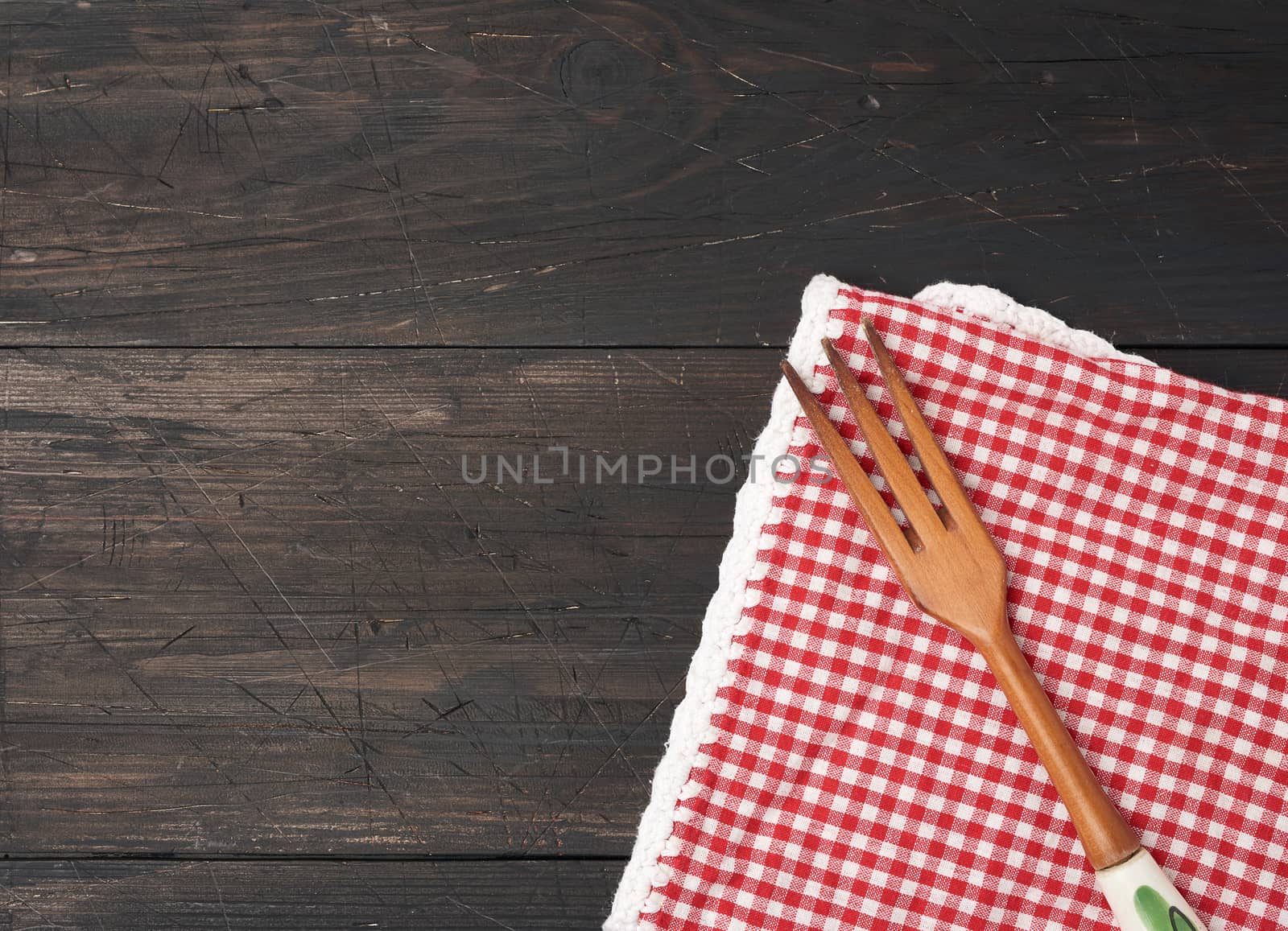 wooden fork lie on a brown wooden background from boards, top view, copy space