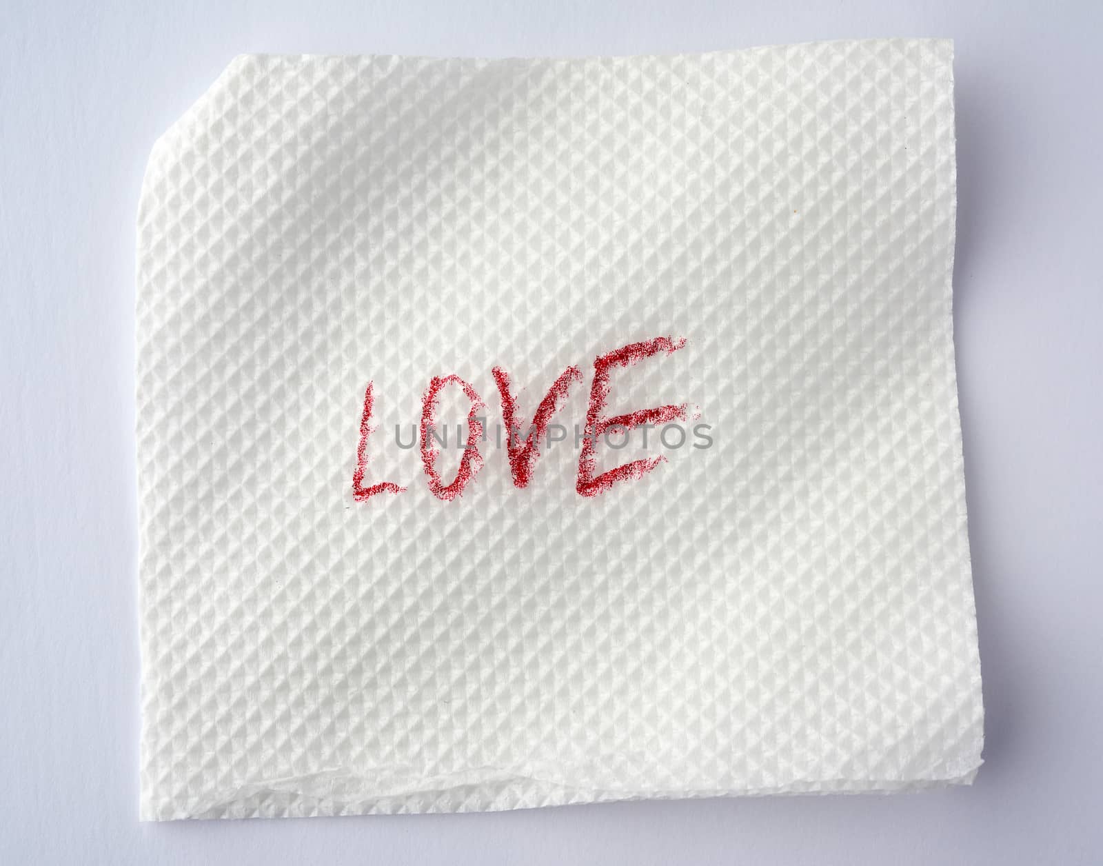 love written in red lipstick on a white paper napkin, date concept, close up