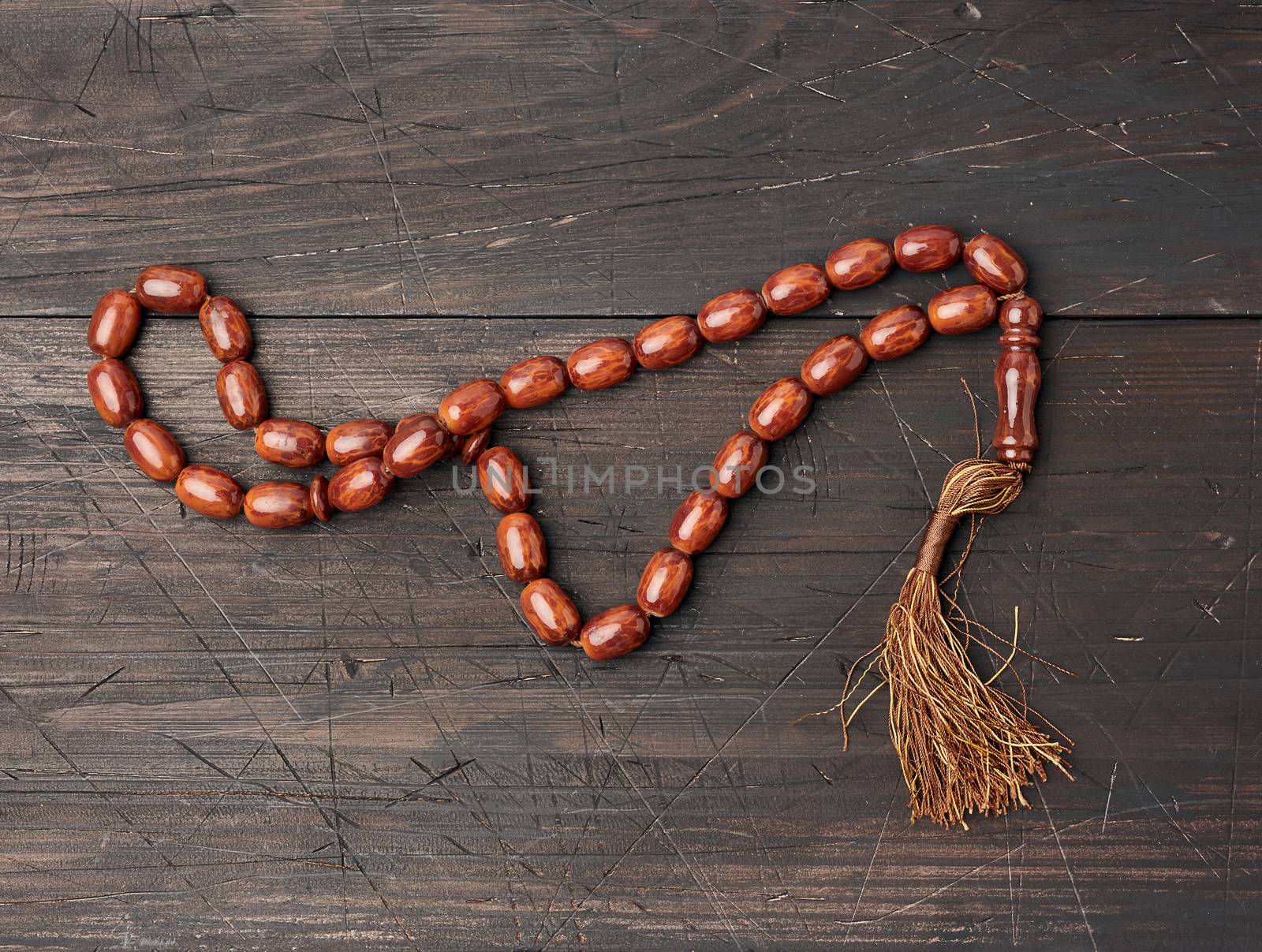 stone prayer rosary on a brown wooden table by ndanko