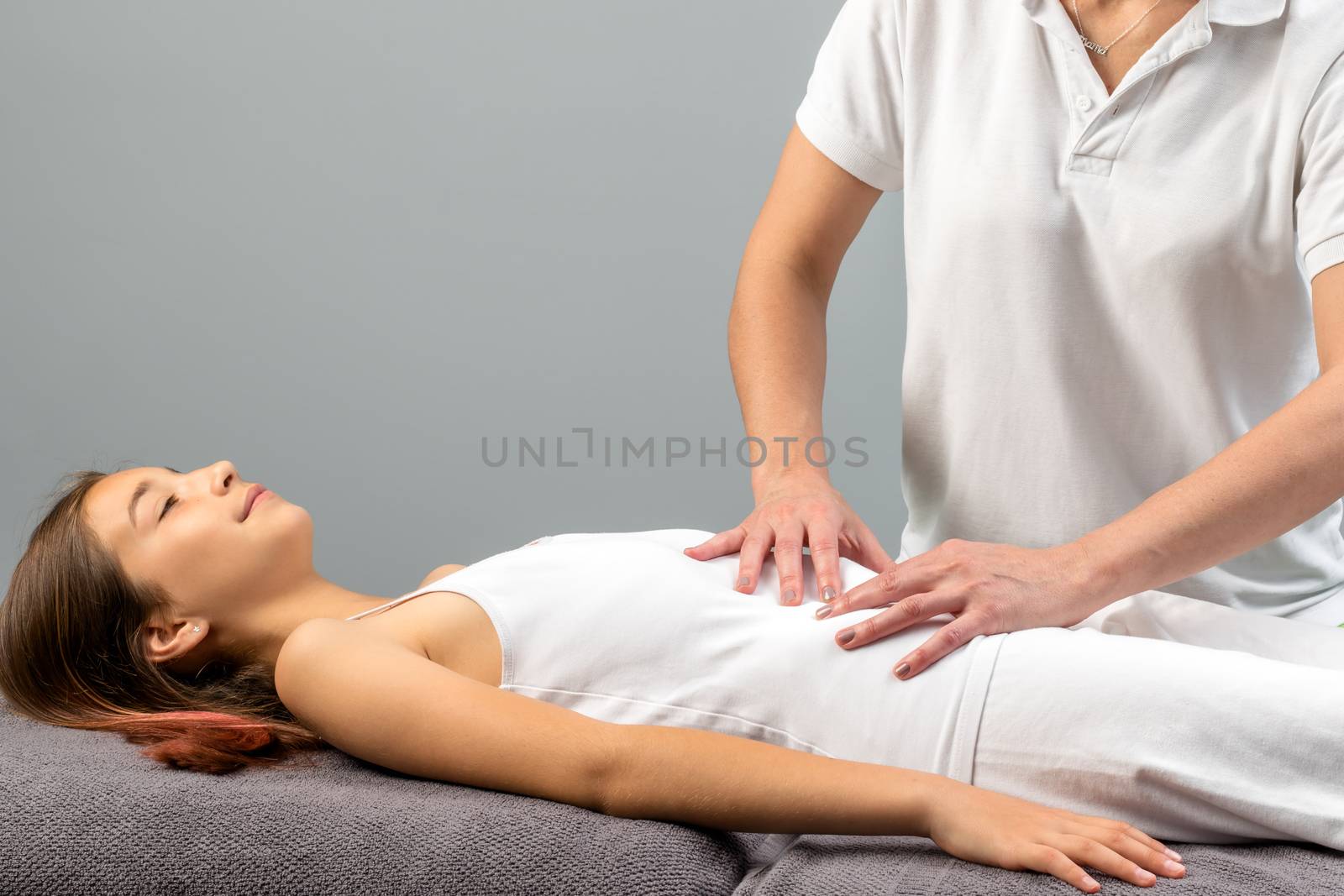 Close up of physiotherapist doing abdomen massage on child.