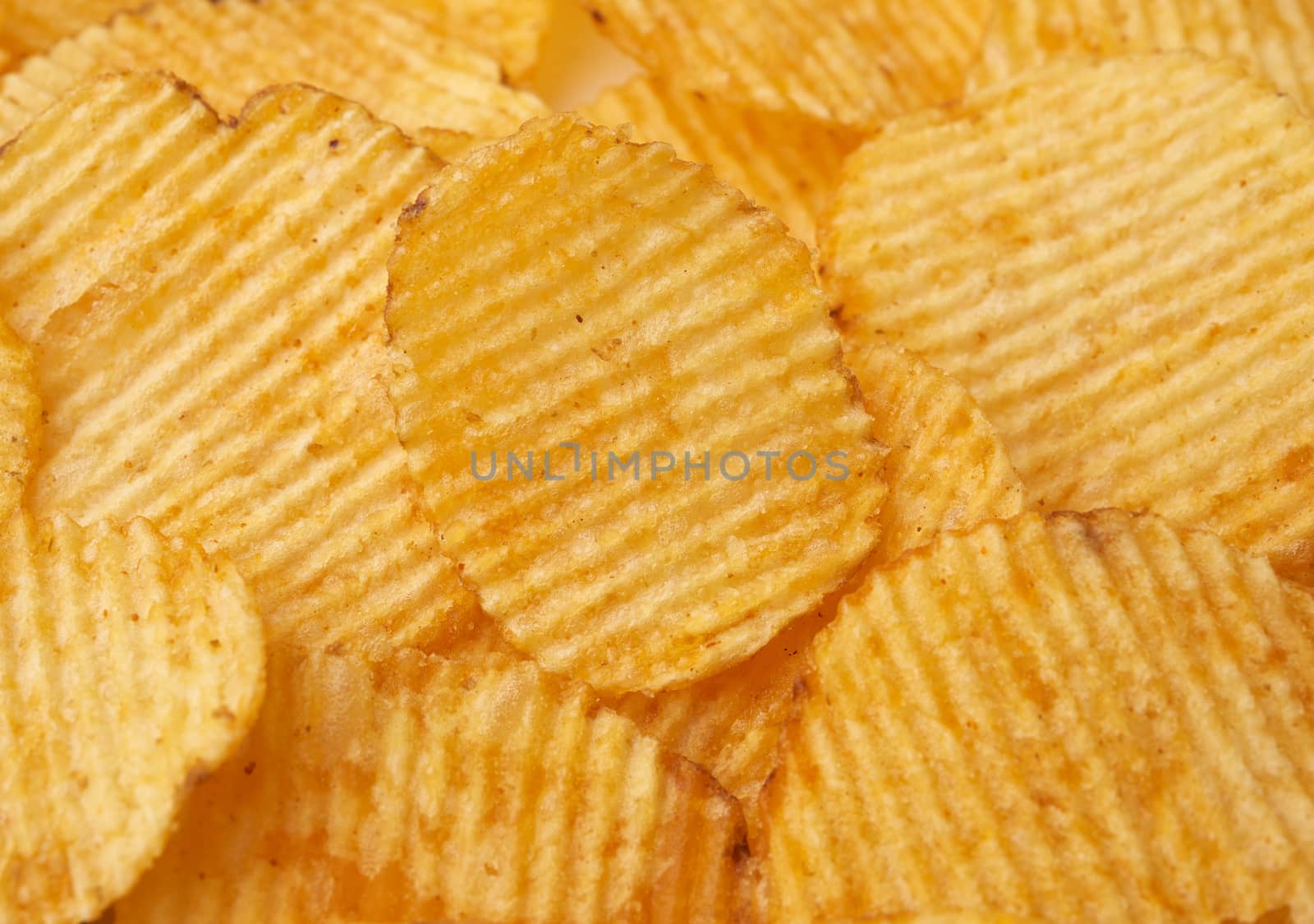 texture of round fried potato corrugated chips, full frame, close up