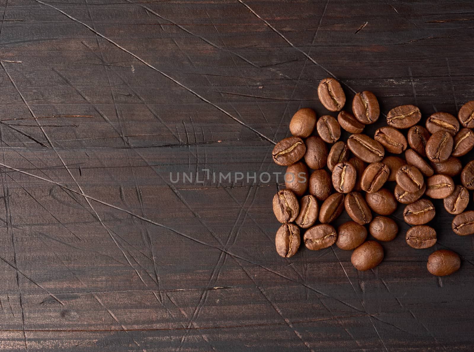 roasted coffee beans arabica on a wooden table, black background by ndanko
