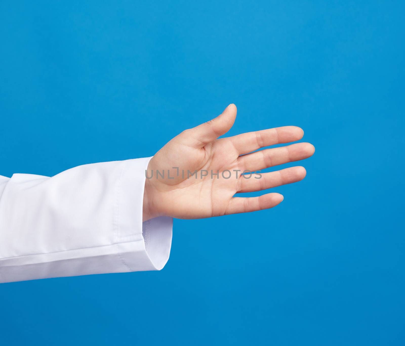 medic in a white coat pulls his hand for a handshake on a blue background, close up