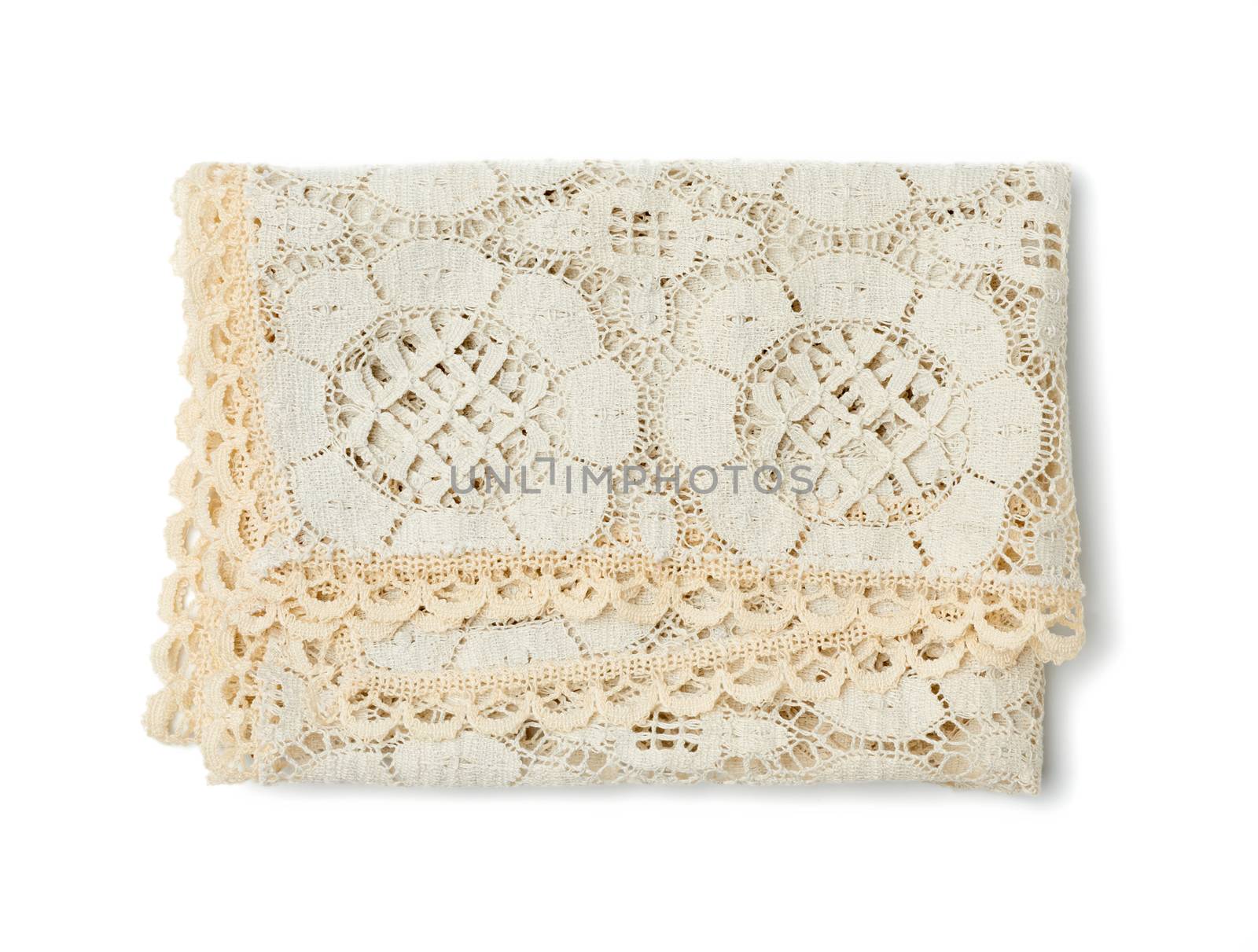 folded beige lace tablecloth and isolated on a white background by ndanko