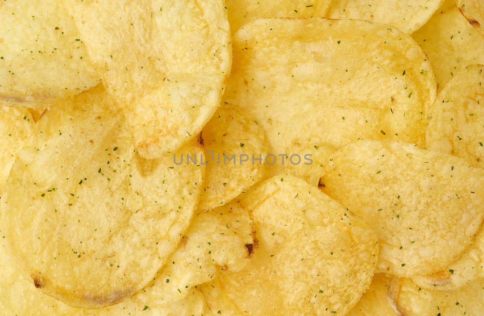 heap of round yellow fried potato chips with dill, food with spi by ndanko