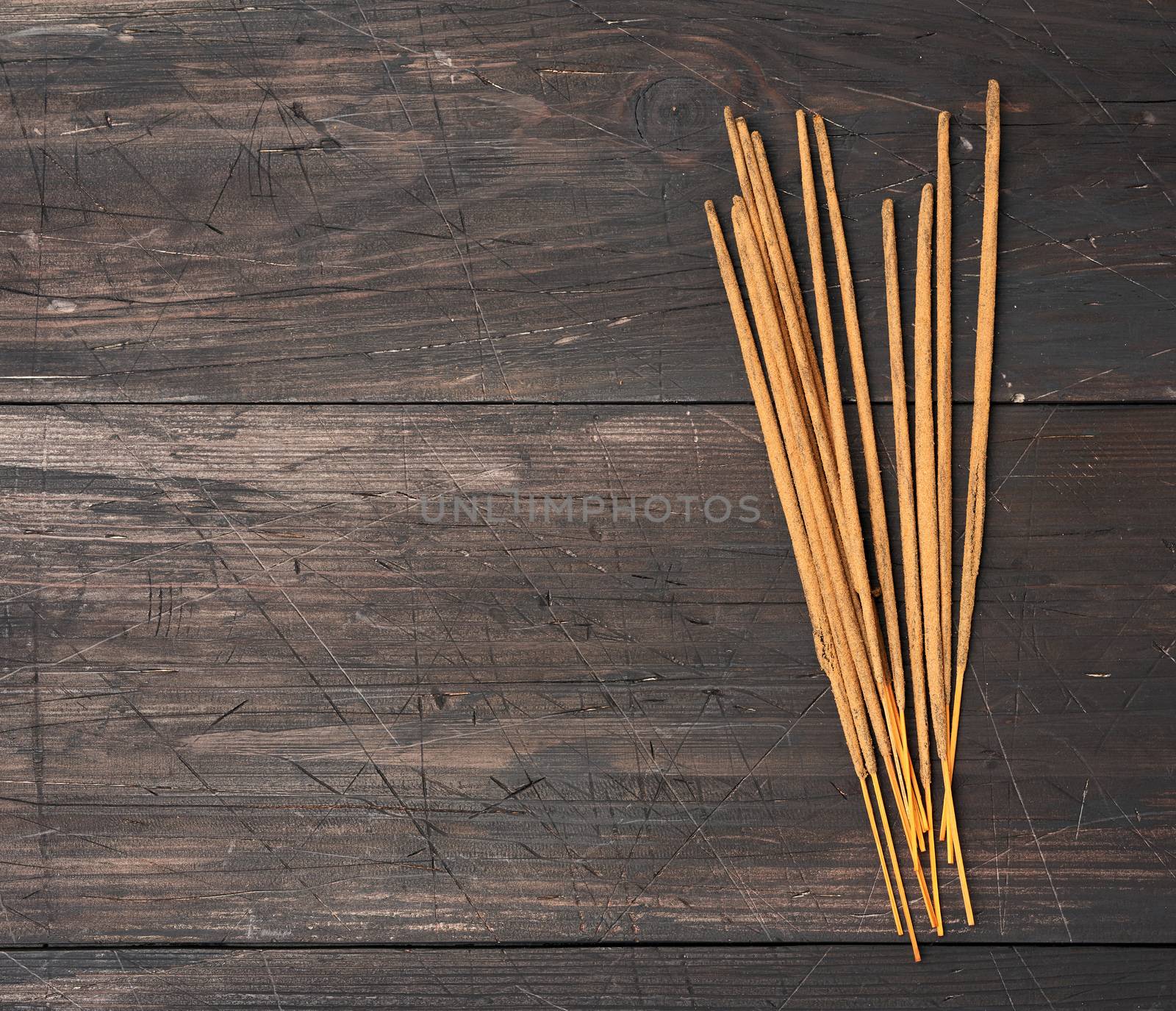stack of incense sticks for rituals on a brown wooden table,  top view, copy space