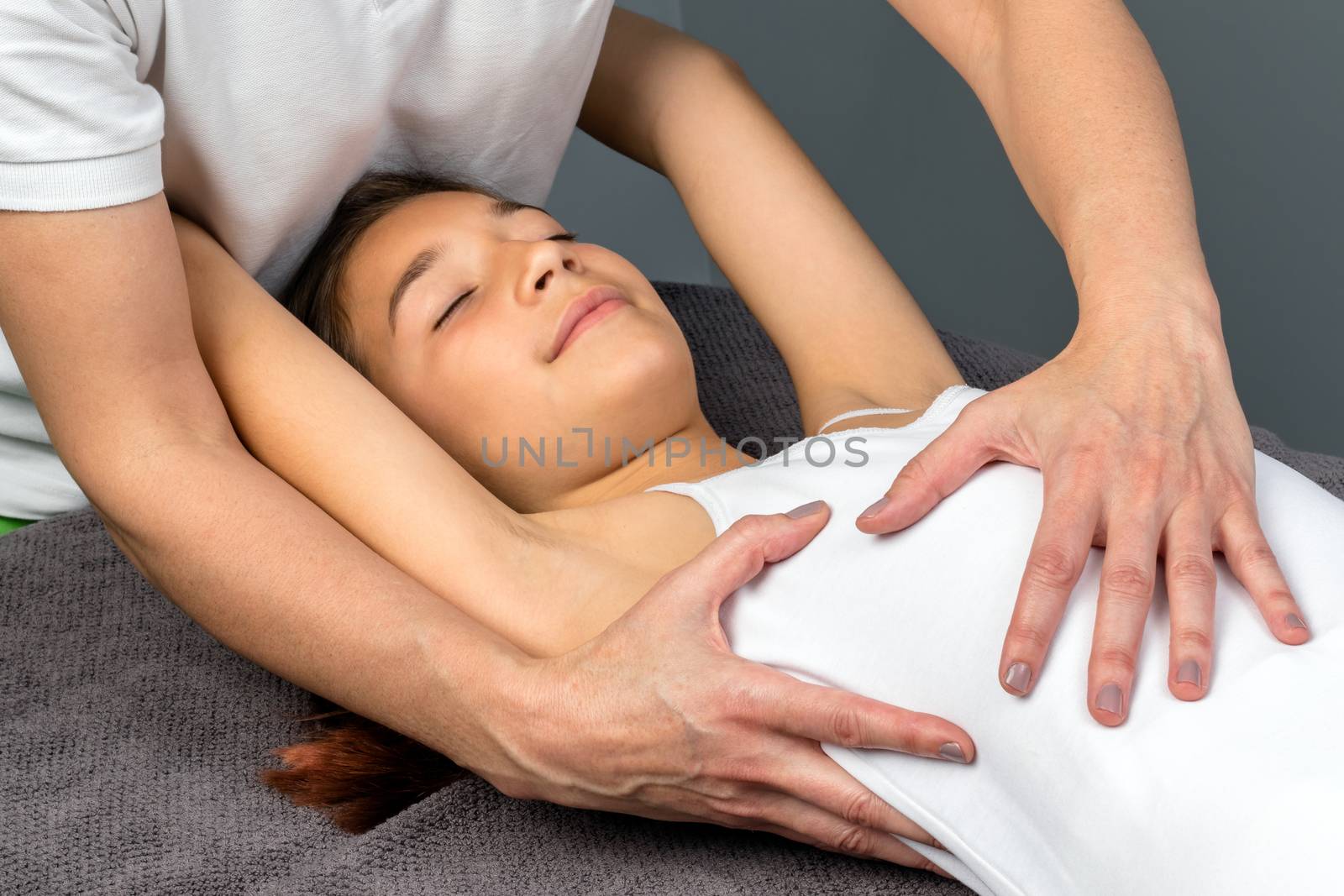 Close up of female osteopath doing thorax massage on child.