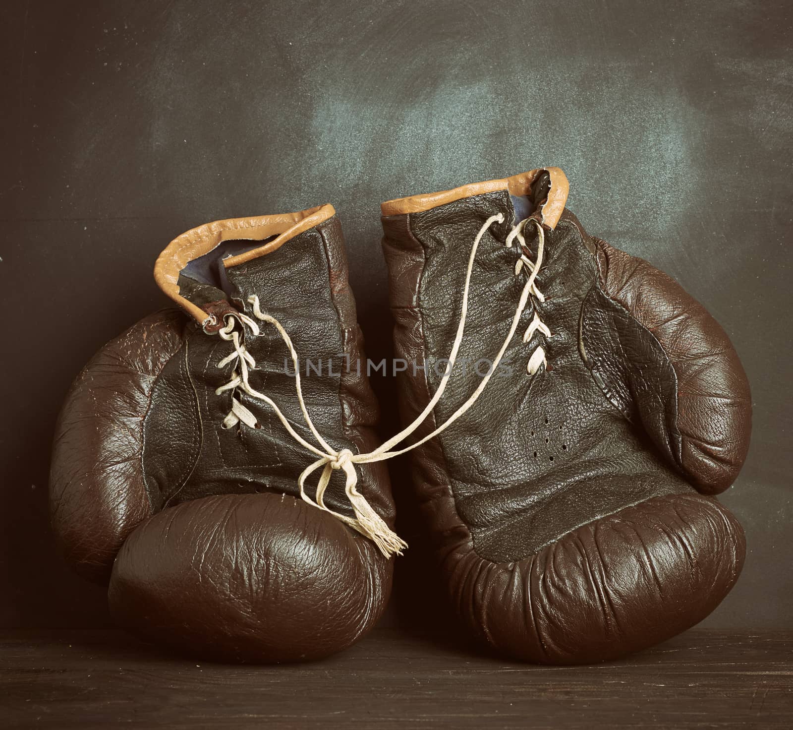 brown leather vintage boxing gloves on a black background, sports equipment, copy space