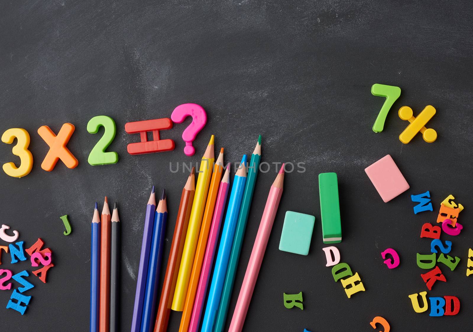 wooden multi-colored pencils, plastic numbers on a black backgro by ndanko
