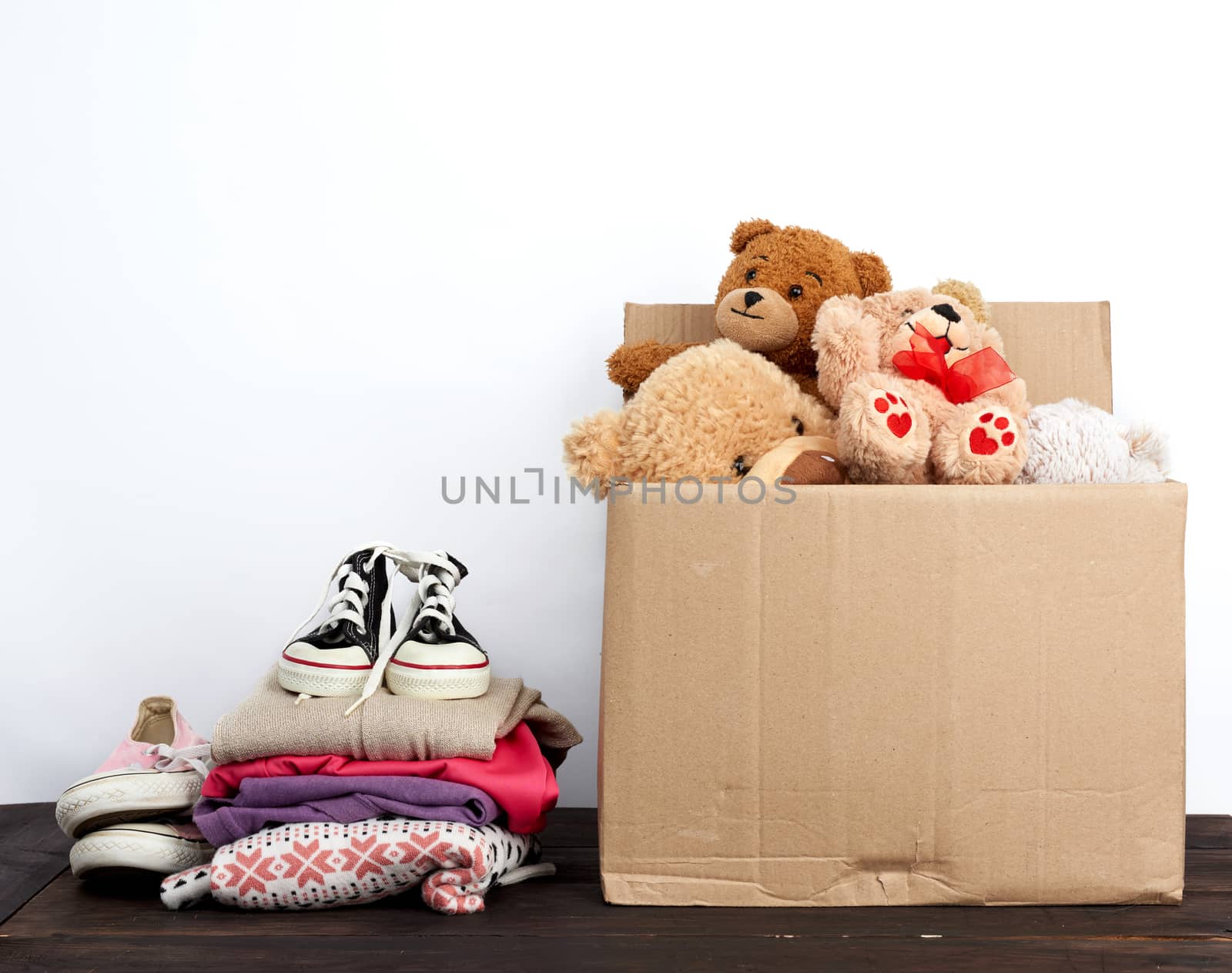 brown cardboard box filled with things and children's toys, concept of moving, volunteering and help