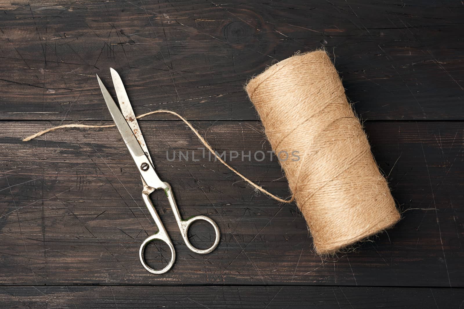 brown thread twisted into a spool and vintage metal scissors by ndanko
