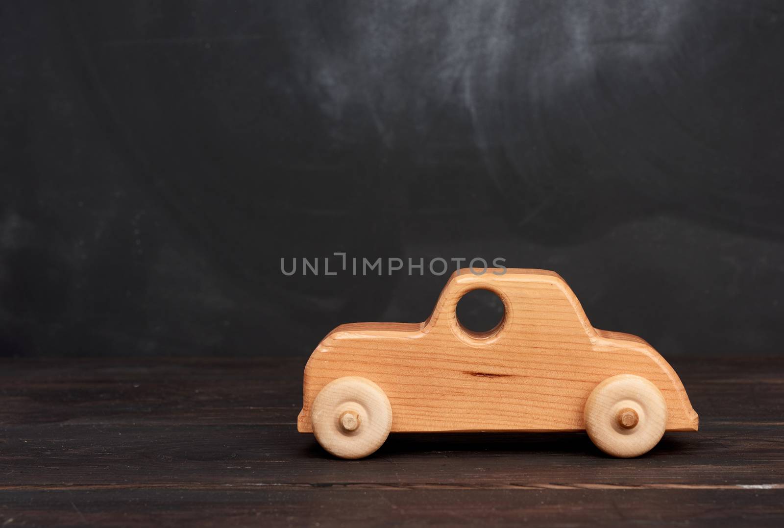 vintage wooden children toy toy car with wheels on black background, eco toy, copy space