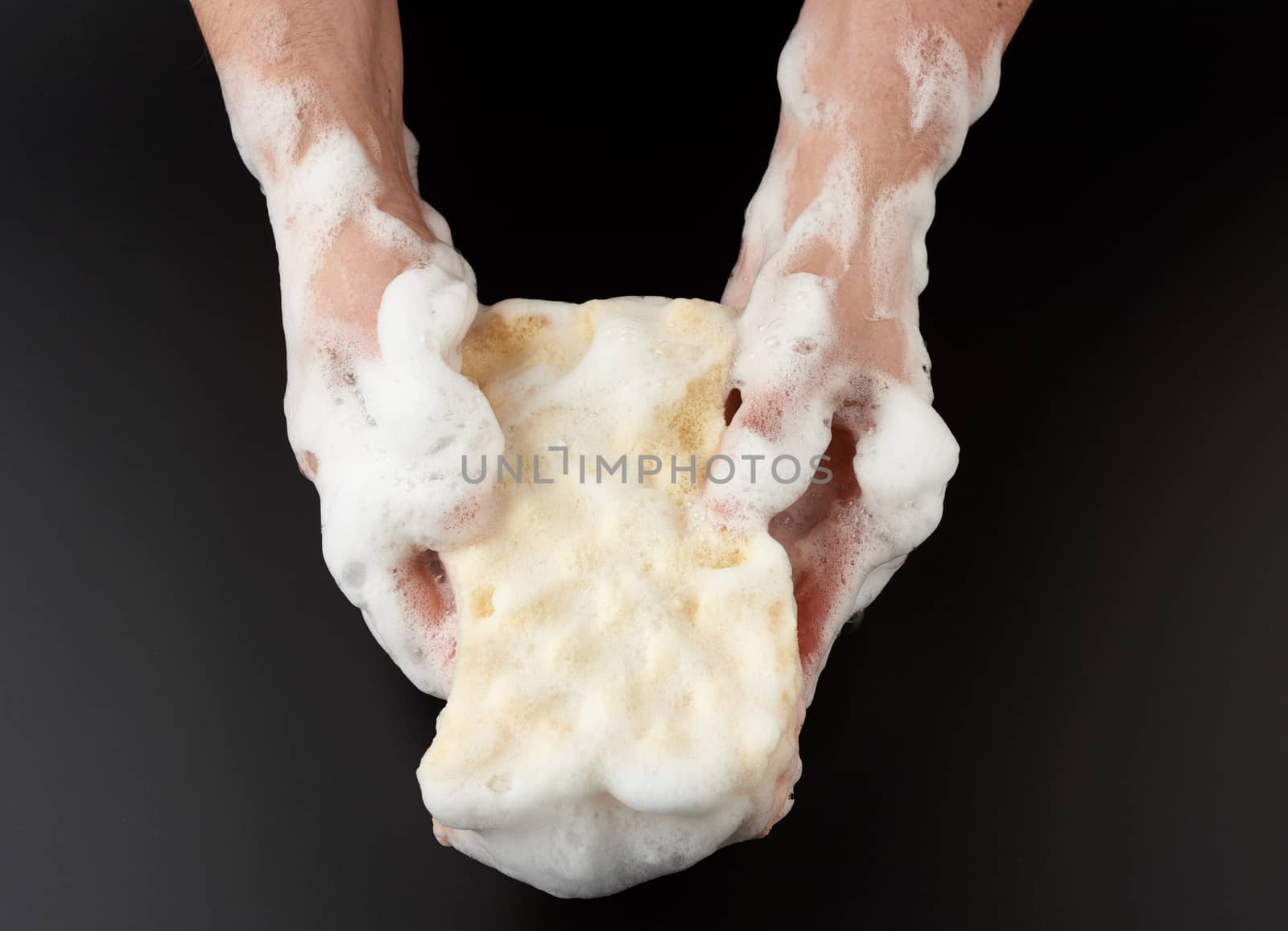 two female hands in white soapy foam hold a wet sponge and wipe  by ndanko