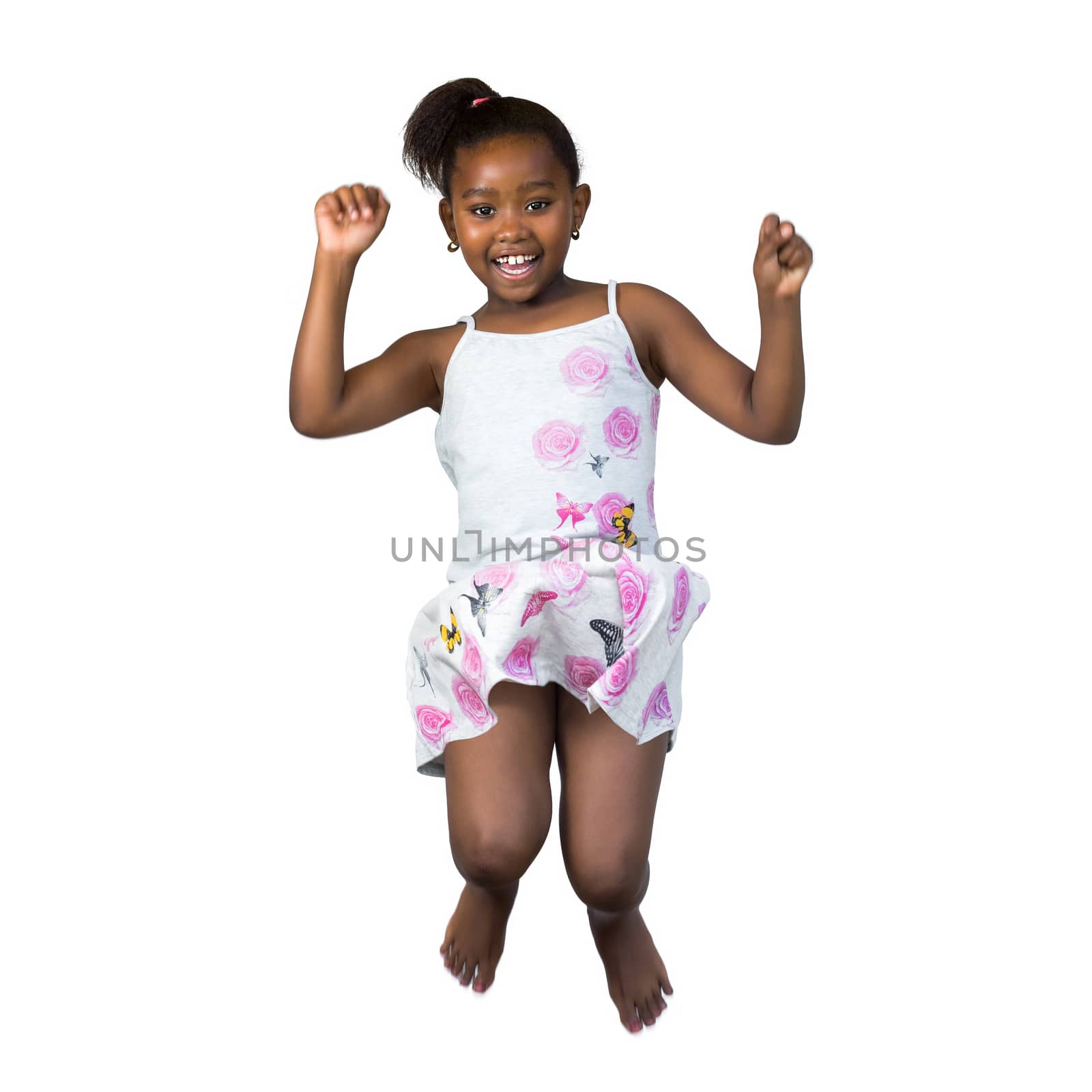 Close up portrait of happy little african girl jumping high wtih arms raised.Isolated on white background.