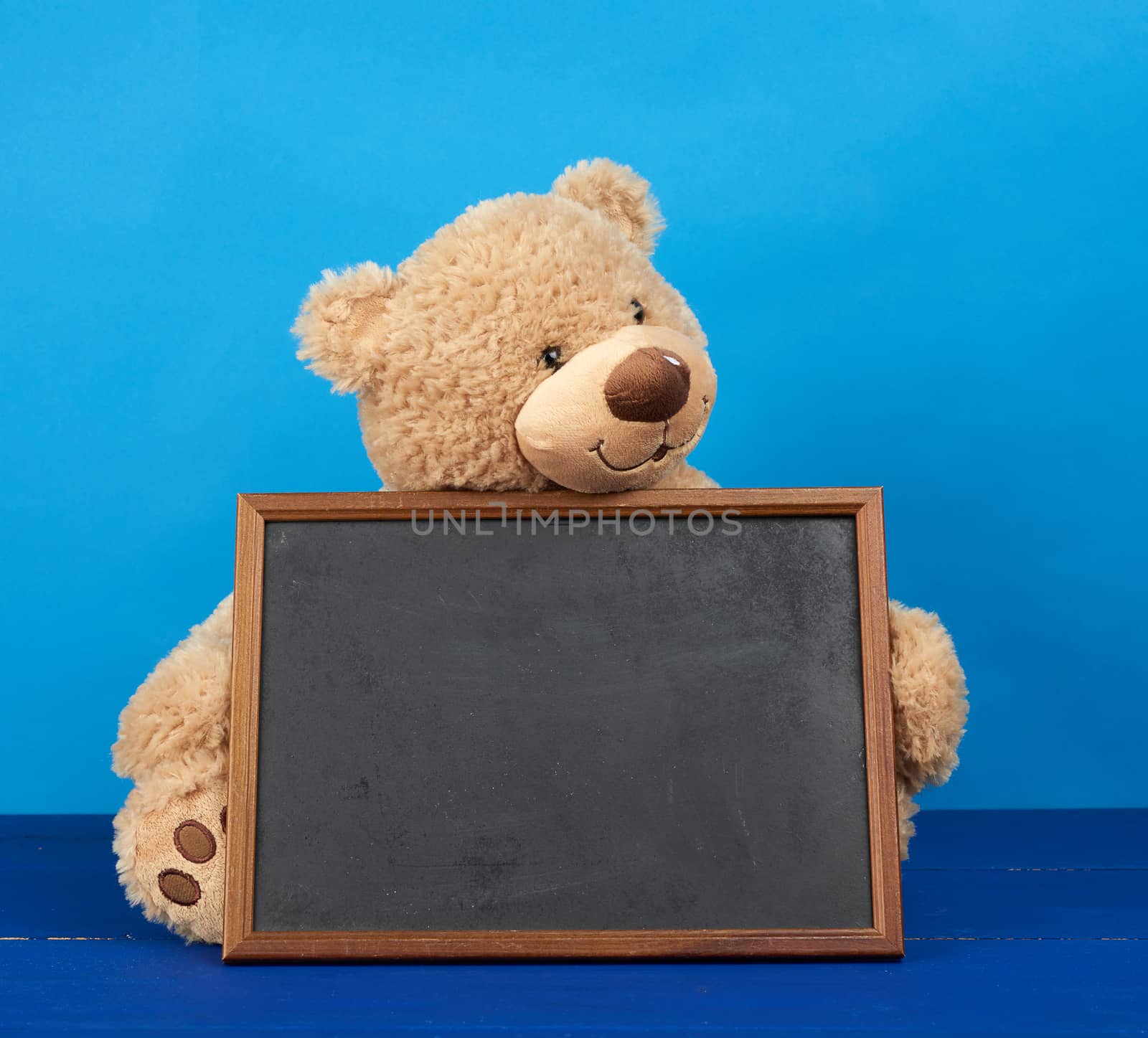 brown teddy bear and empty wooden rectangular frame, chalk board for writing a to-do list. Back to school