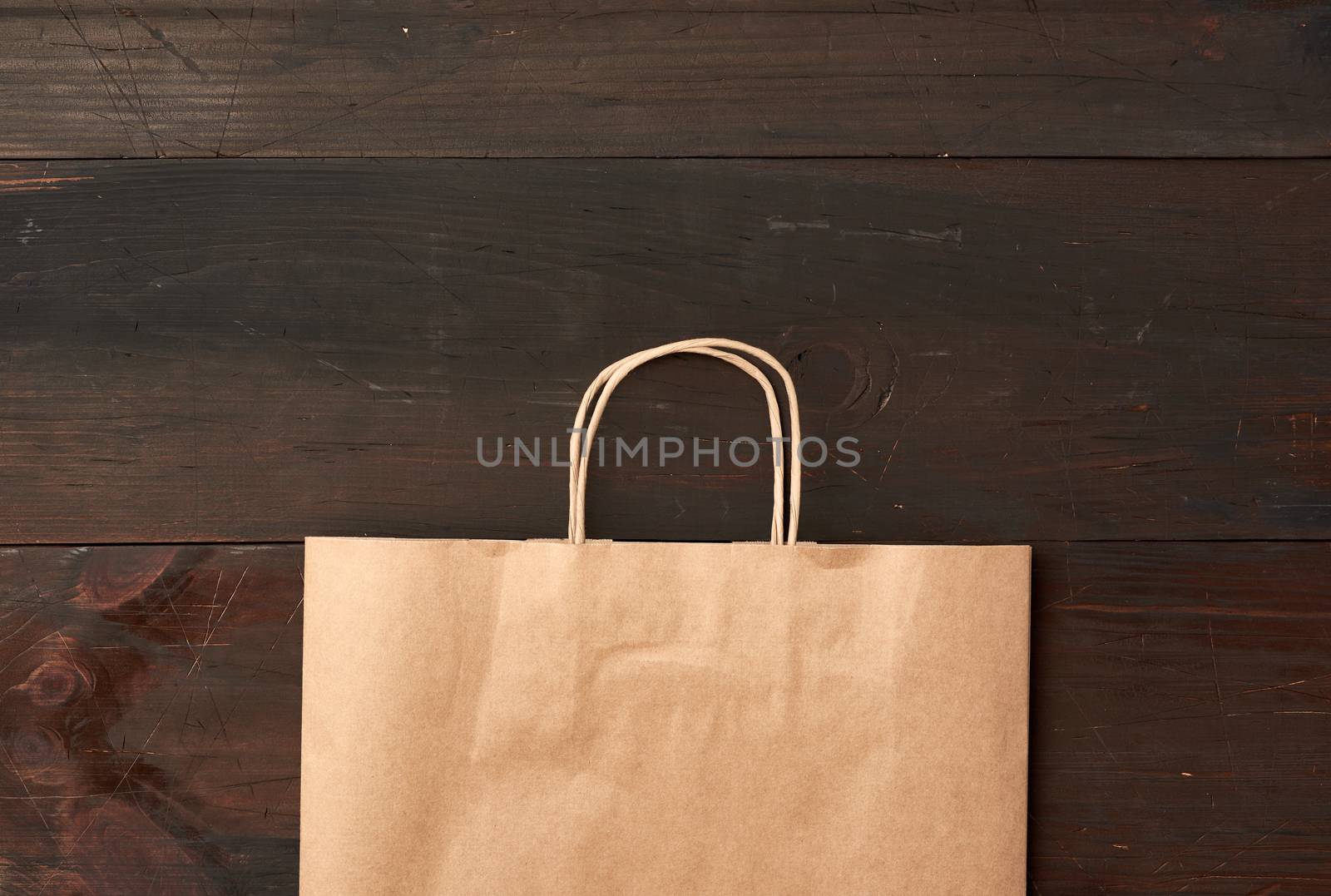 brown paper bag for food packaging on a brown wooden background by ndanko