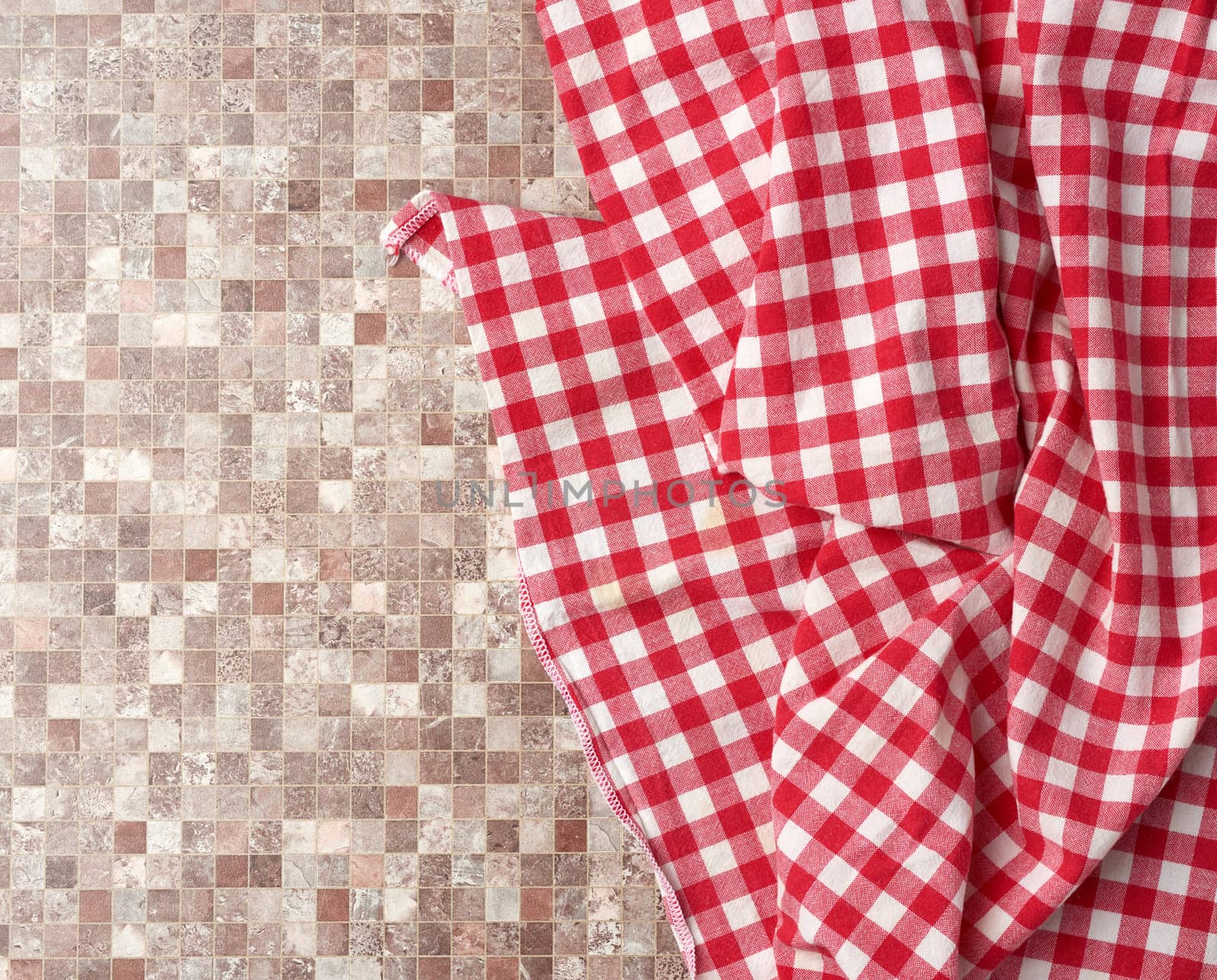 red checked cotton kitchen towel on a brown kitchen surface, top by ndanko