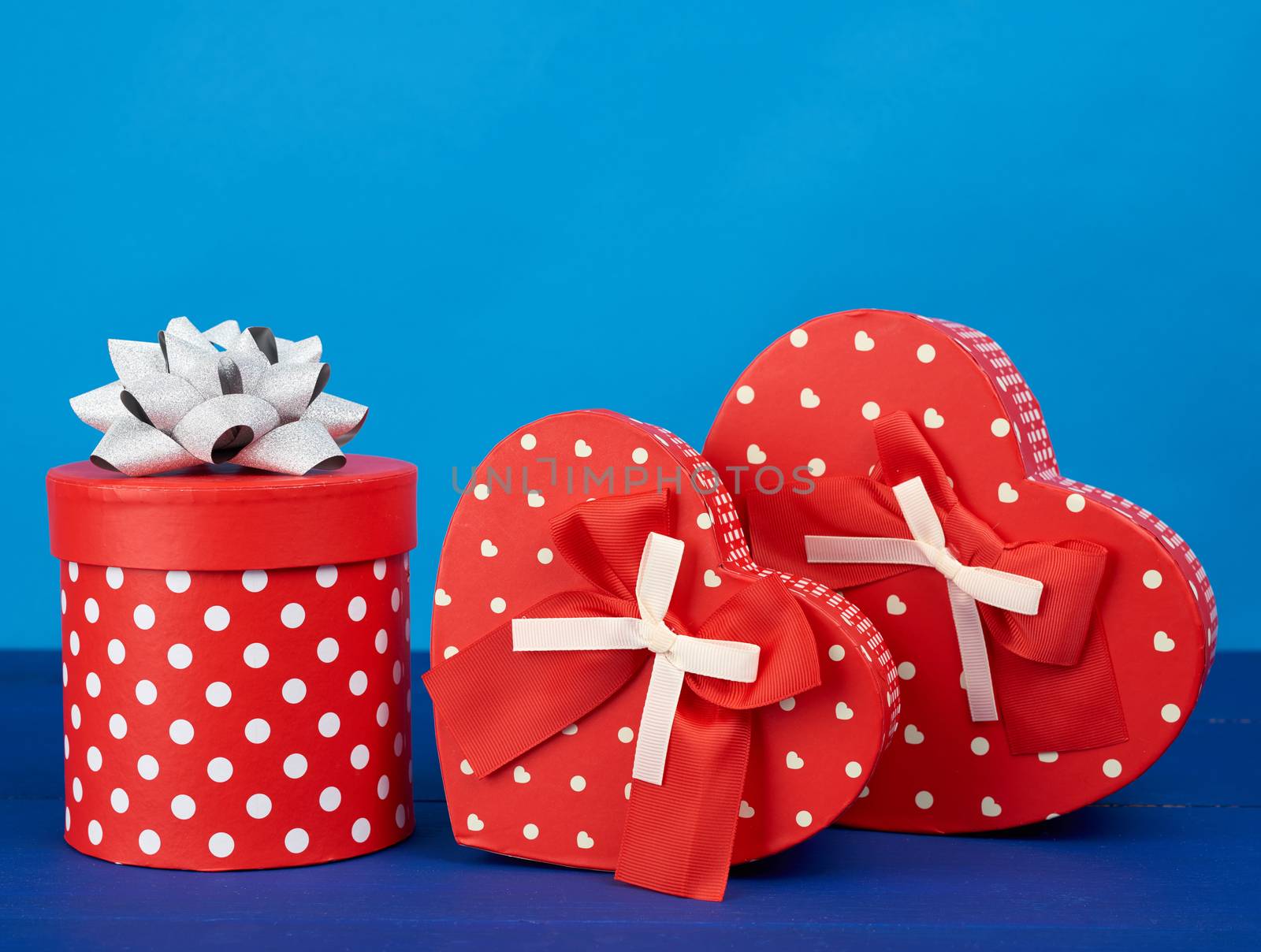 red cardboard boxes with gifts on a blue background, festive backdrop