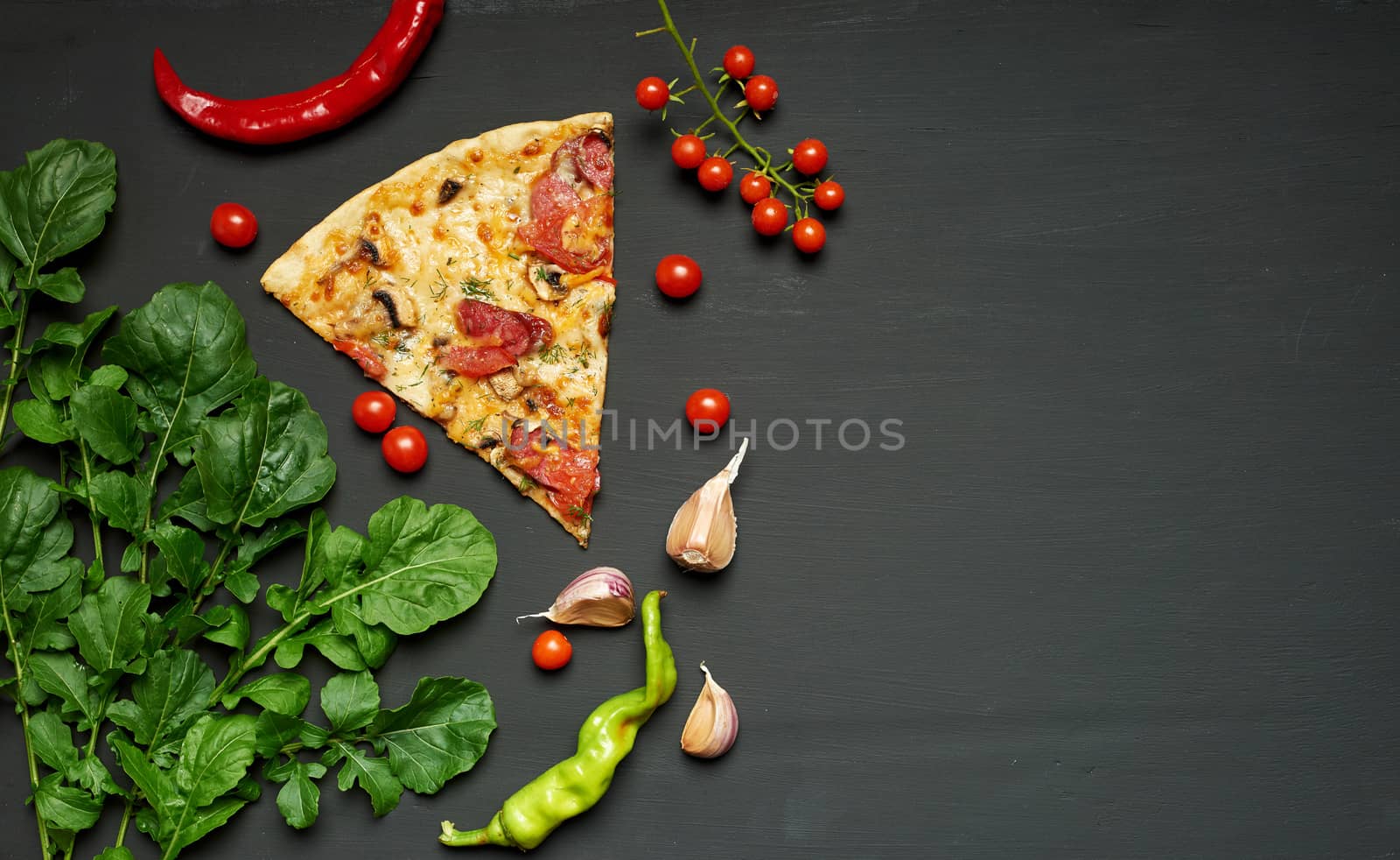 triangular piece of baked pizza with mushrooms, smoked sausages, tomatoes and cheese, black background, flat lay, copy space