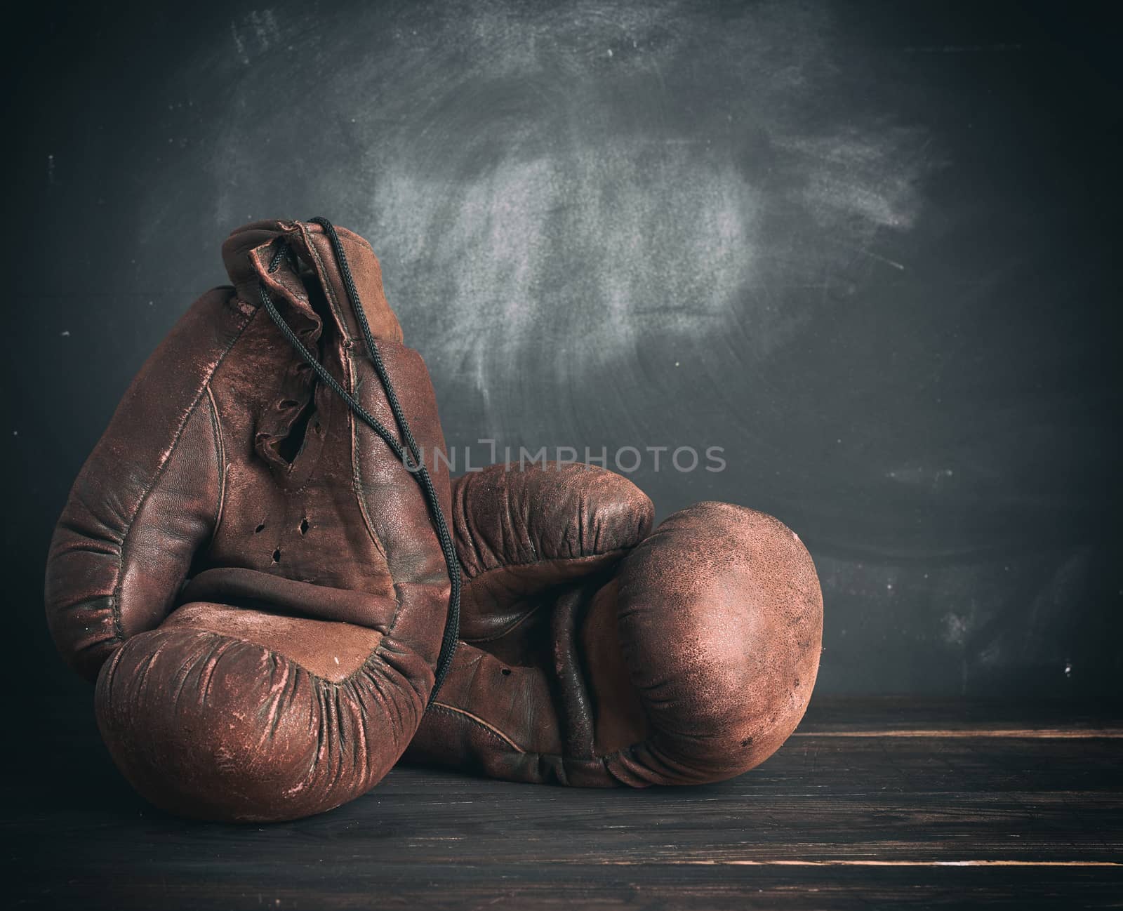 brown leather vintage boxing gloves on a black background, sports equipment, copy space