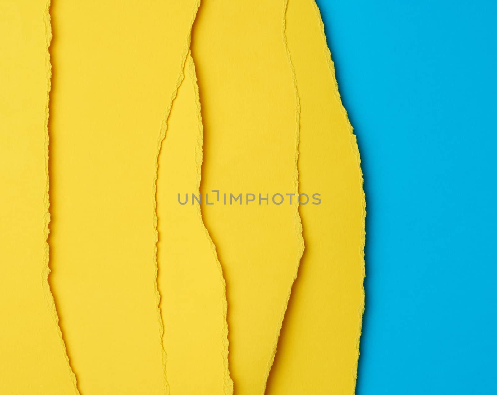 background of layered yellow torn paper with a shadow on a blue background, backdrop and template for designer