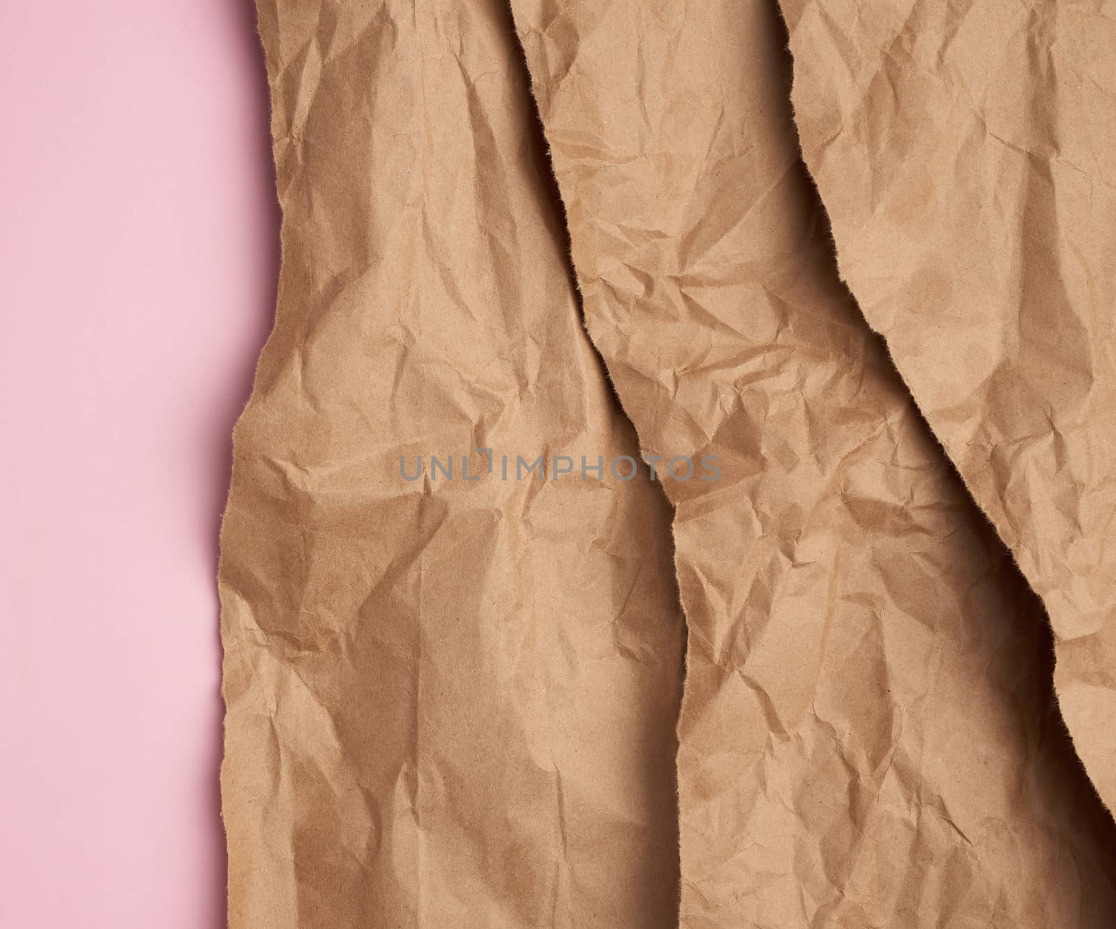 background of layered brown torn paper with a shadow on a pink background, backdrop and template for designer, copy space